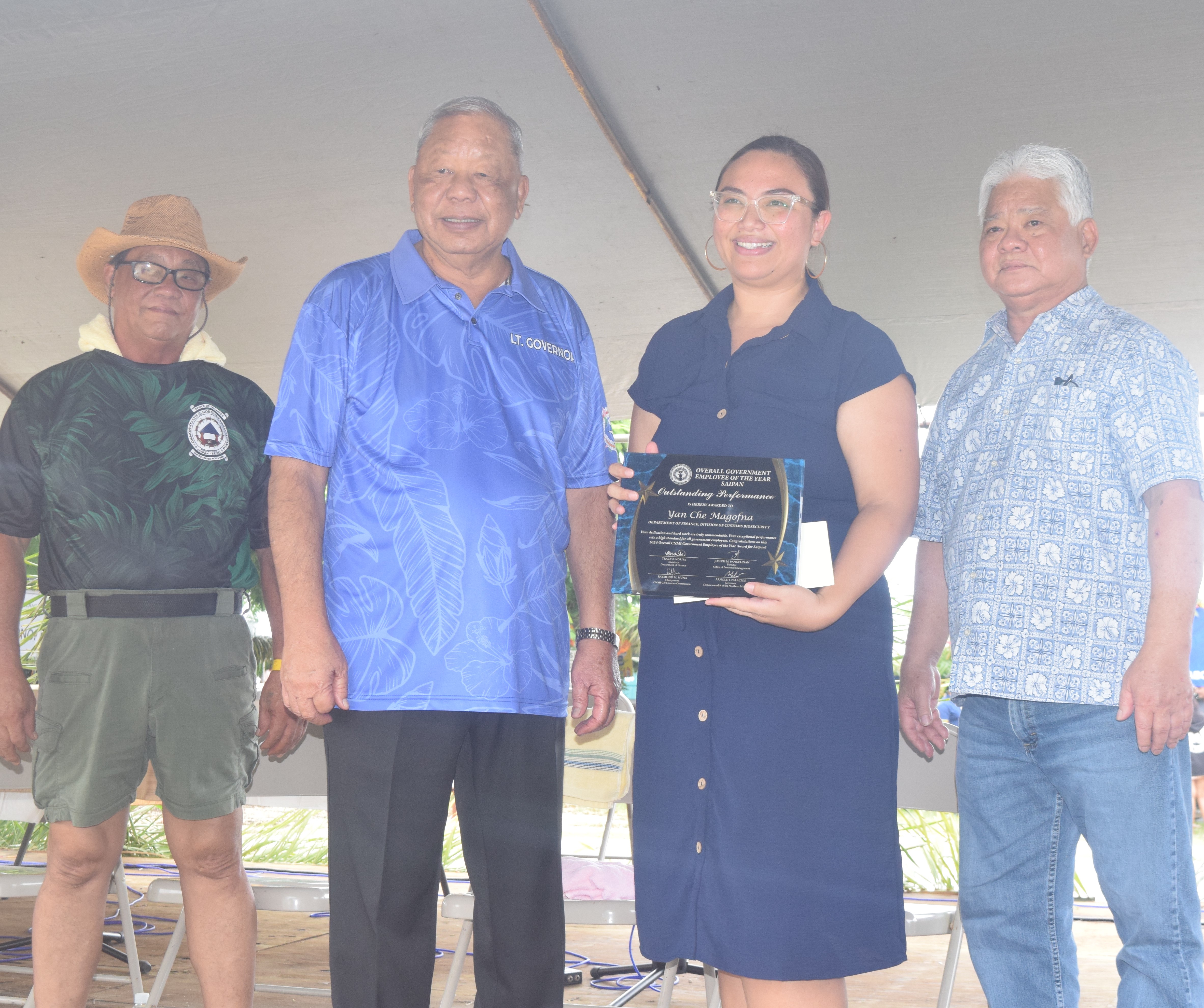 Finance Secretary Tracy B. Norita, 2nd right, holds the award on behalf of the overall government employee of the year, Yan Che Magofna, (not in photo) as she poses for a photo with Gov. Arnold I. Palacios, right, Lt. Gov. David M. Apatang, second left, and Saipan Mayor Ramon Blas “RB”  Camacho, left.