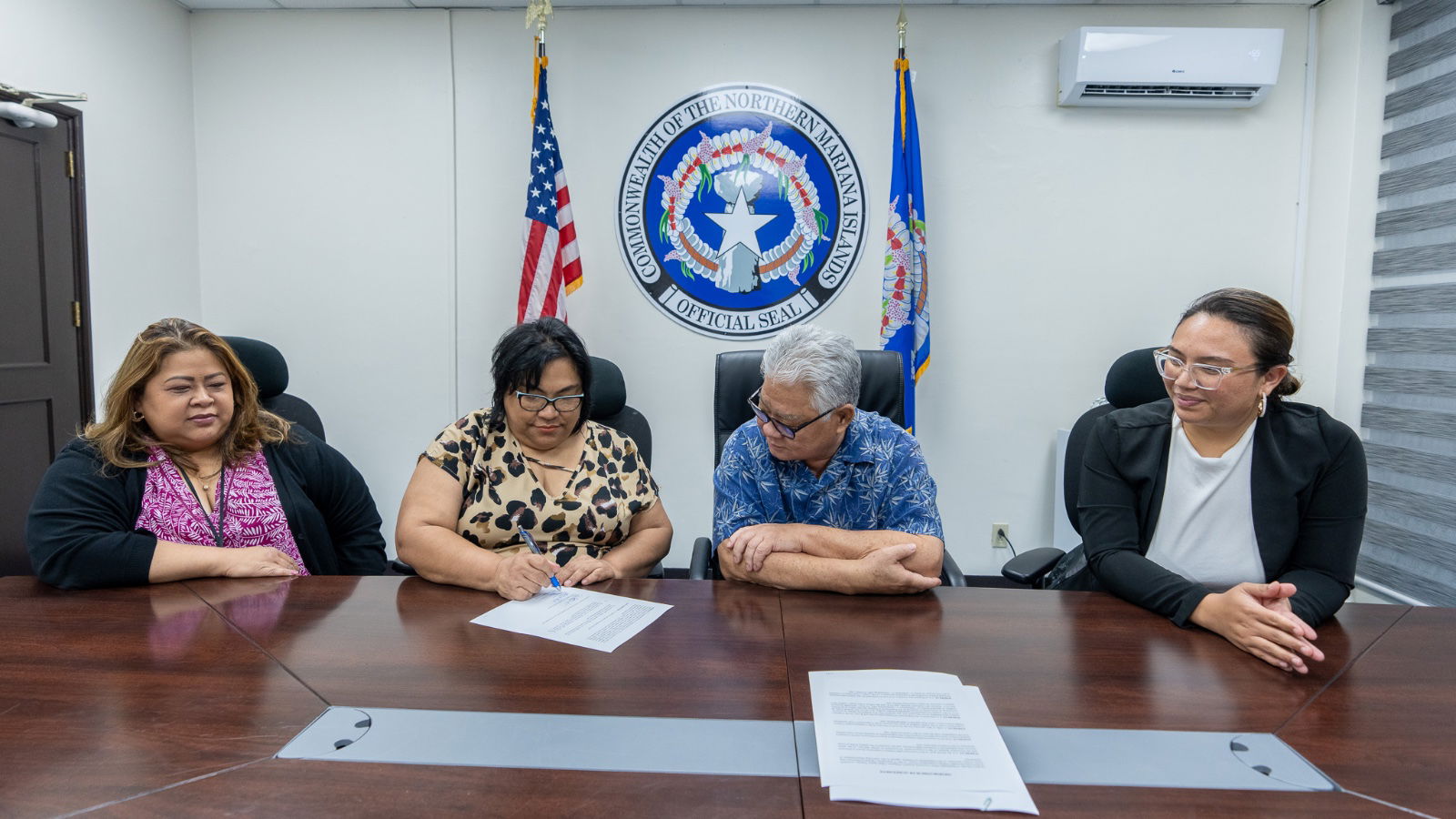 Commonwealth Utilities Corporation Chief Finance Officer Betty Terlaje, left, Finance Secretary Tracy Norita, right, and Gov. Arnold I. Palacios, 2nd right, look on as CUC Board Chair Janice Tenorio signs a memorandum of agreement pertaining to the central government’s $10.9 million in outstanding utility bills on Friday.