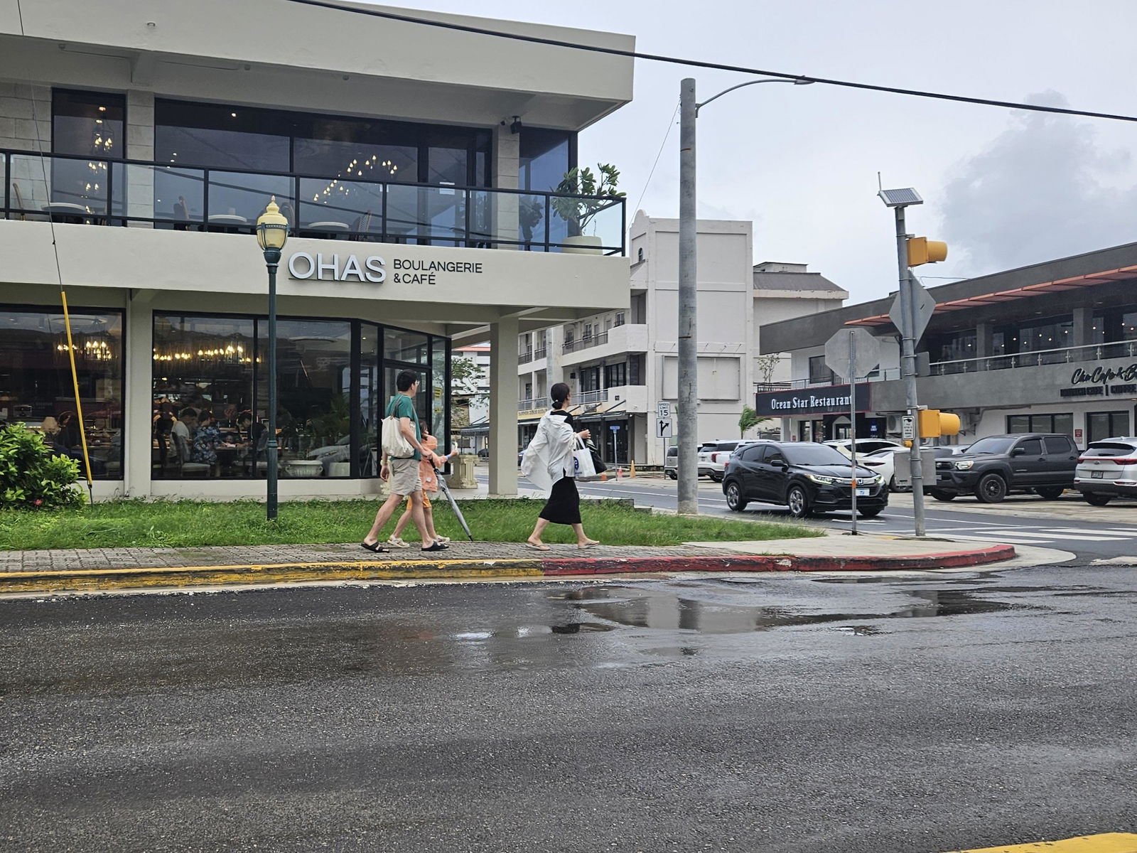 Tourists walk in downtown Garapan amid inclement weather on Monday.
