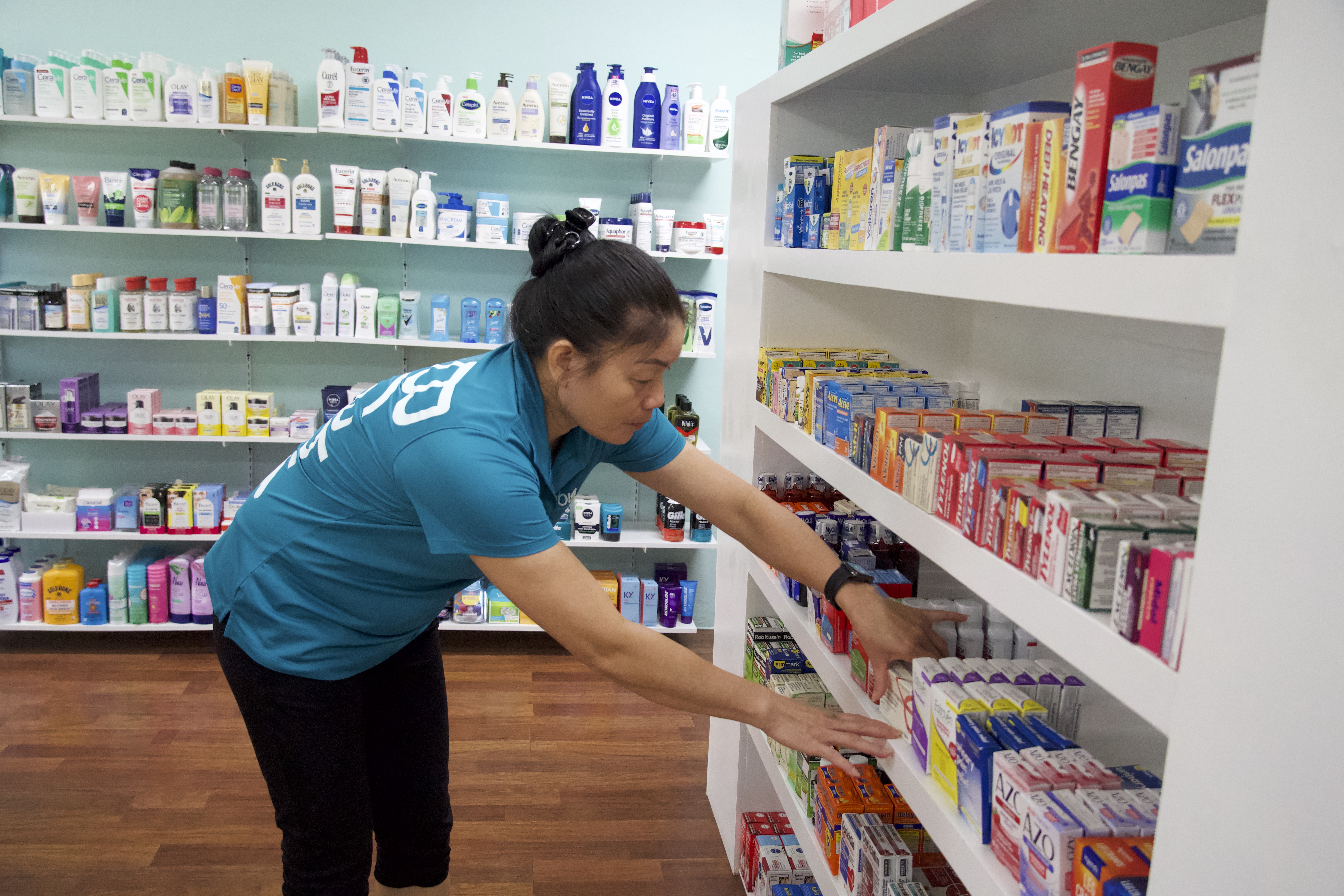 Brabu Pharmacy's pharmacy Aide Loc Thi Vu checks the shelves to see if she needs to restock.