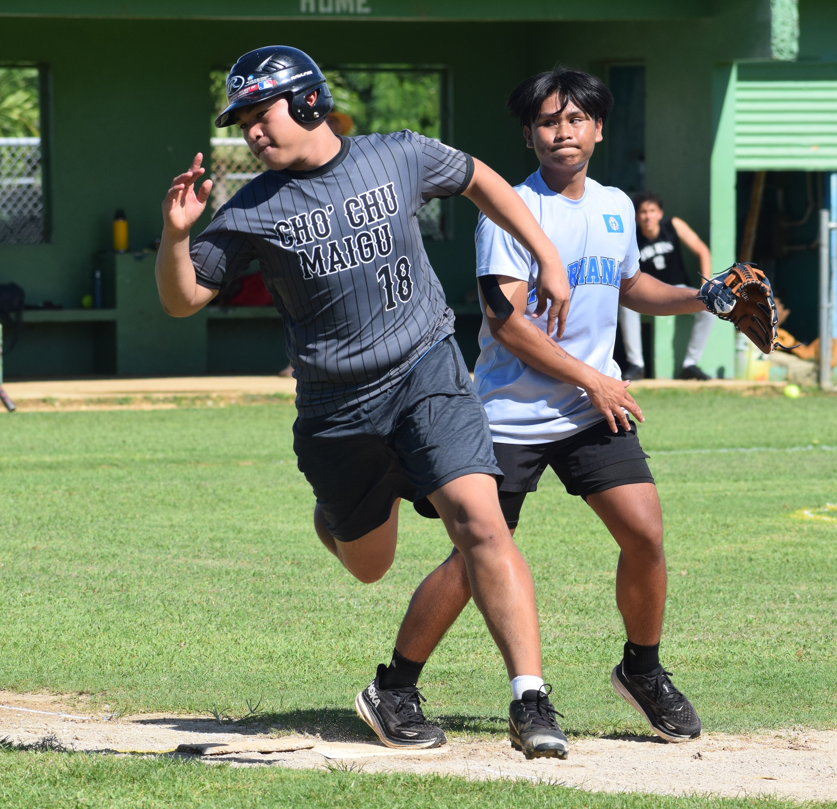 Marianas High School's Thomas Chong makes it to first base after hitting a single in the first inning.