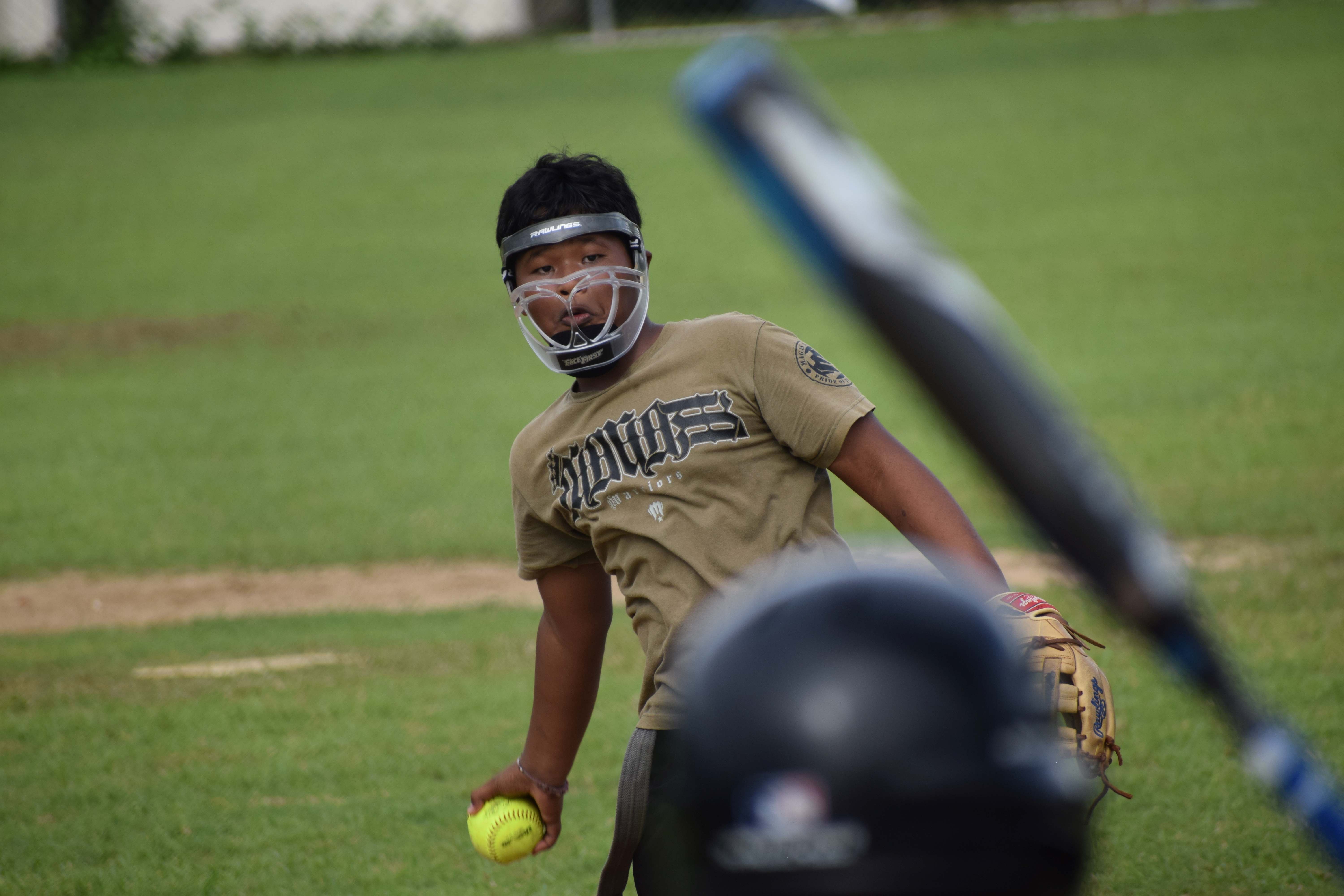 Kagman High School pitcher Avenbert Kaipat tosses the ball at a Marianas High School batter.