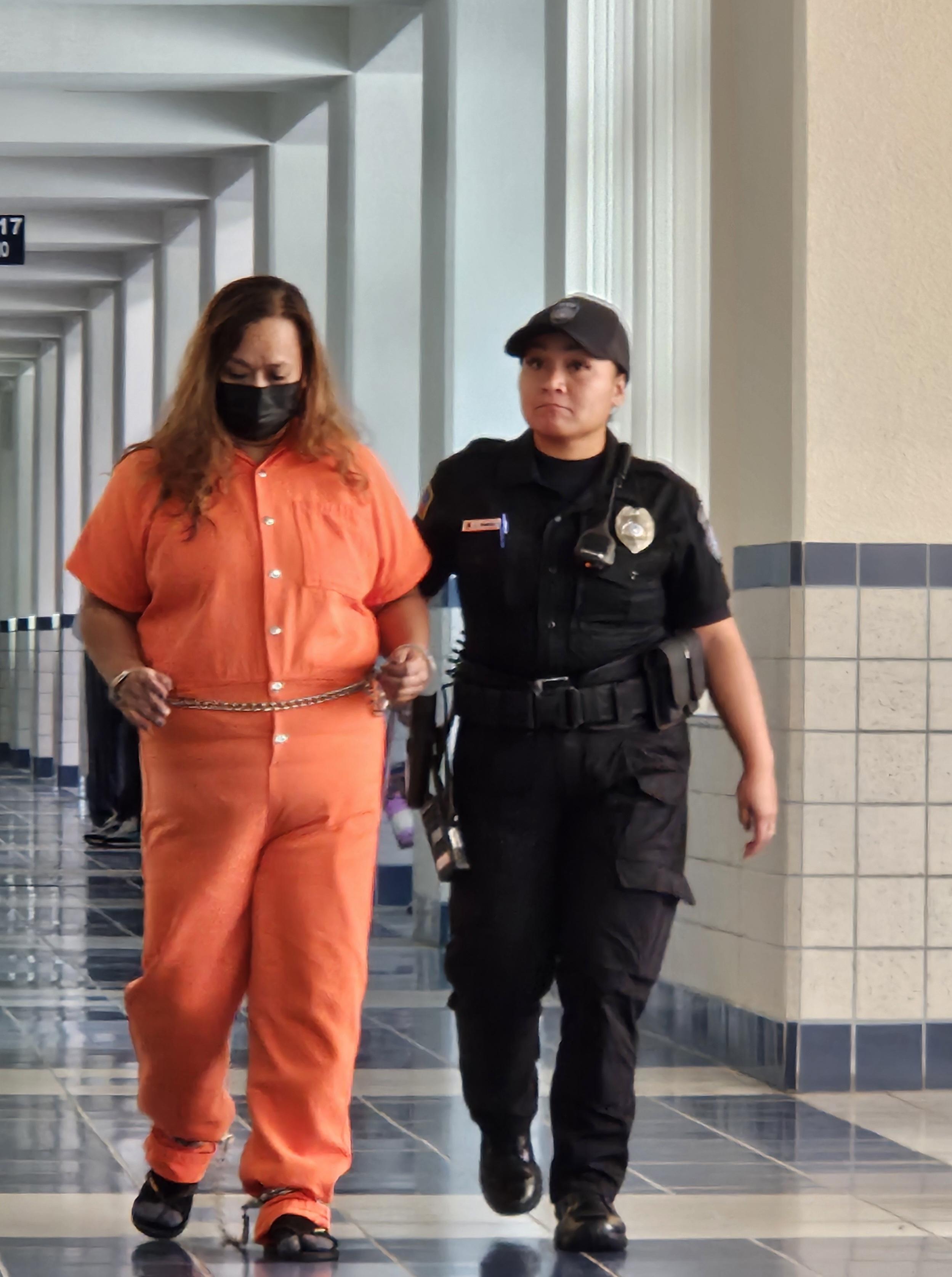 Millie Reyes Mantanona, 49, is escorted by a corrections officer to a preliminary hearing at the Guma Hustisia on Wednesday, Sept. 18.