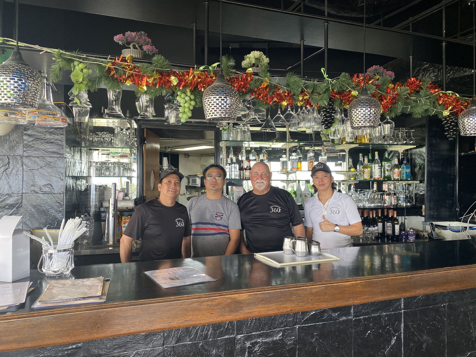 Andrew Colburn, third left, poses with some of the staff of 360 Revolving Restaurant, where lunch hours have been reinstated.