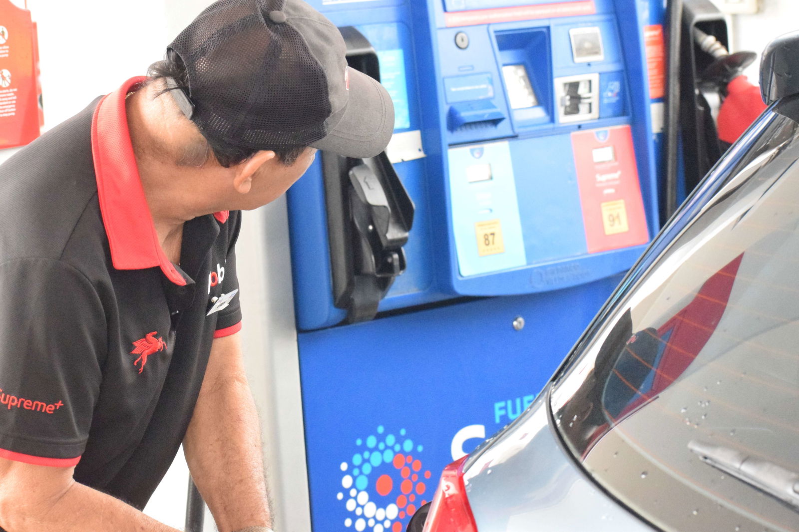 Gasoline attendant Efren Pascual fills the tank of a customer's car at Mobil Oil Marianas station on Middle Road in Garapan on Wednesday.