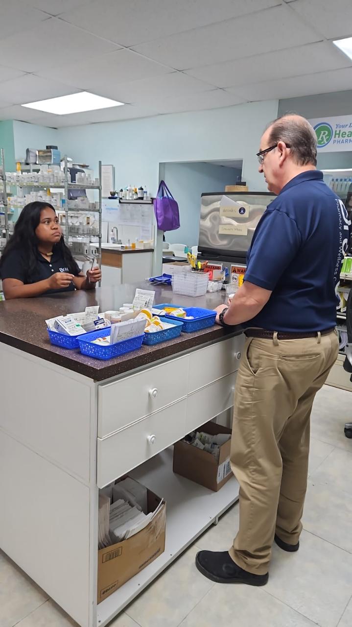 Brabu Pharmacy co-owner Ted Parker, right, talks with some of his staff.