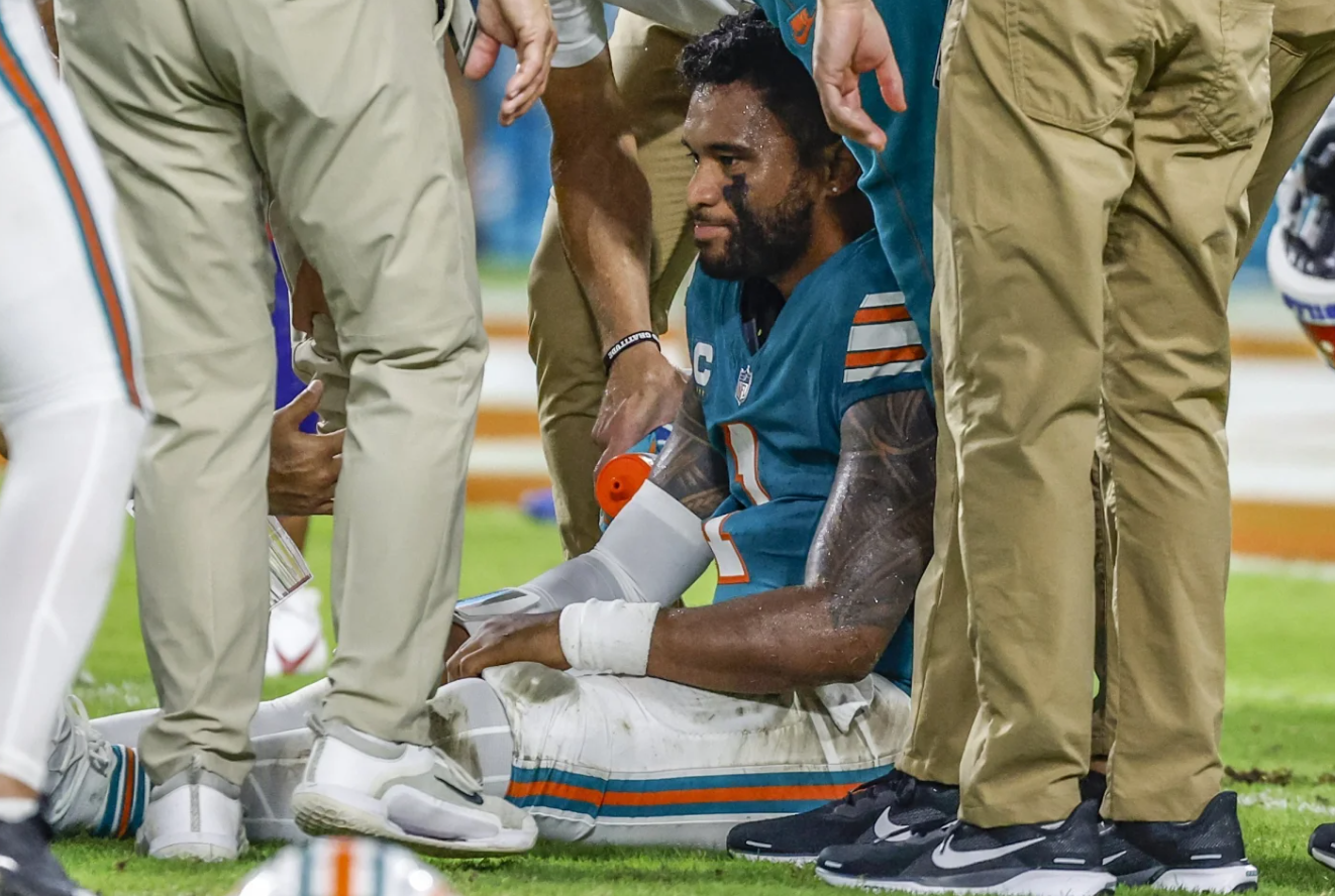 Miami Dolphins quarterback Tua Tagovailoa sits on the field as he is attended to after an injury during a game against the Buffalo Bills on Thursday, Sept. 12, 2024.