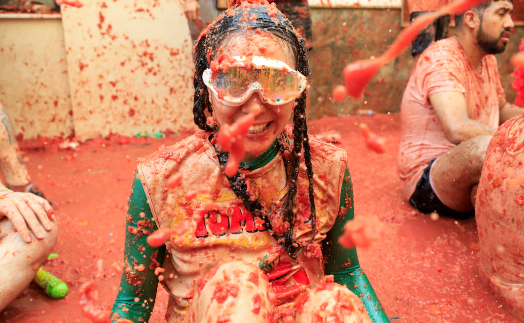 A participant covered in tomato pulp looks on, as people attend the annual food fight festival “La Tomatina” in Bunol, near Valencia, Spain, Aug. 28, 2024.