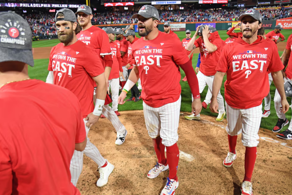 Philadelphia Phillies first baseman Bryce Harper (3), designated hitter Kyle Schwarber (12) and catcher Garrett Stubbs (21) celebrate winning National League East Division with a win against the Chicago Cubs at Citizens Bank Park in Philadelphia, Pennsylvania, Sept. 23, 2024.