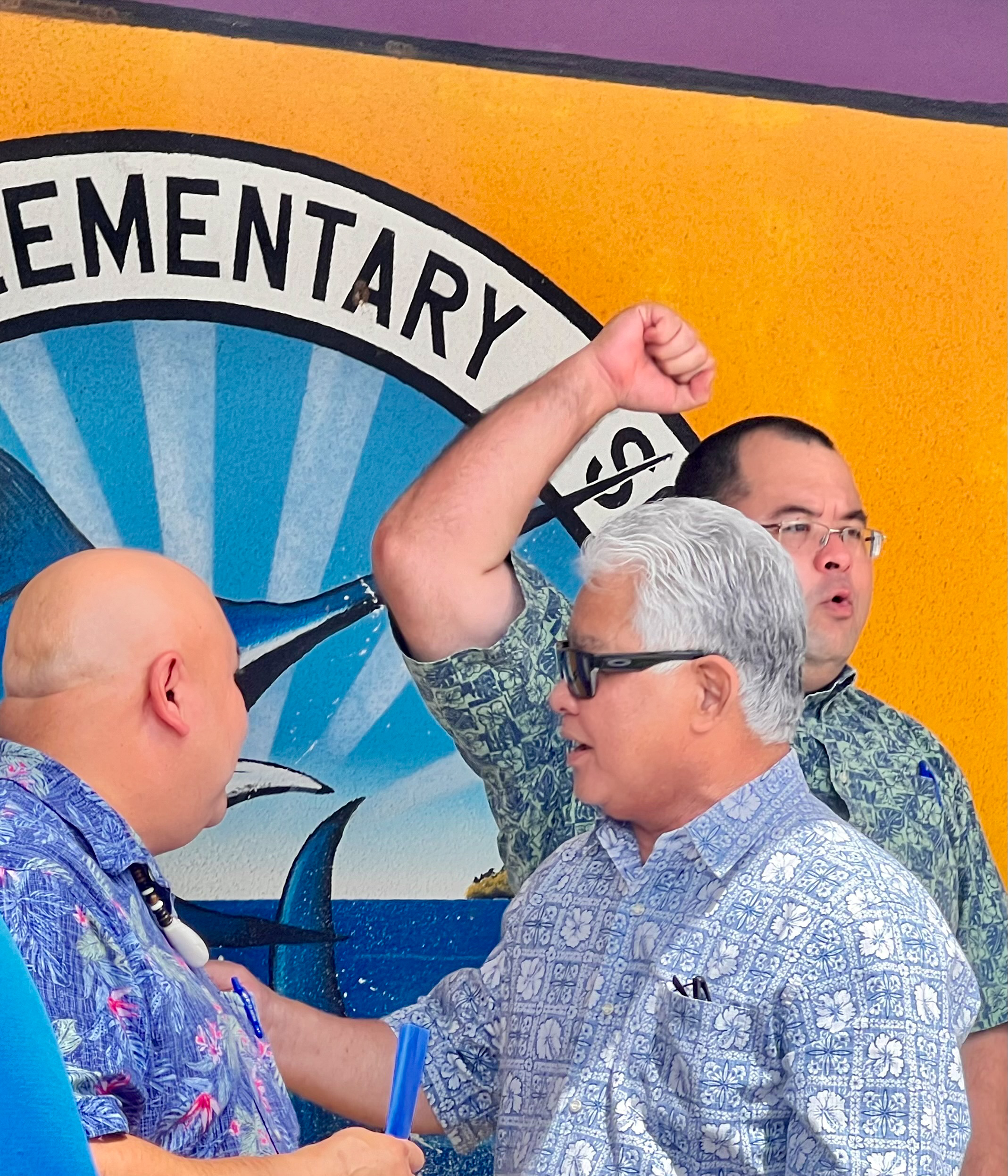 Gov. Arnold I. Palacios and Commissioner of Education Dr. Lawrence F. Camacho congratulate each other as House Speaker Edmund S. Villagomez celebrates the unveiling of the new security and alarm infrastructure investment.