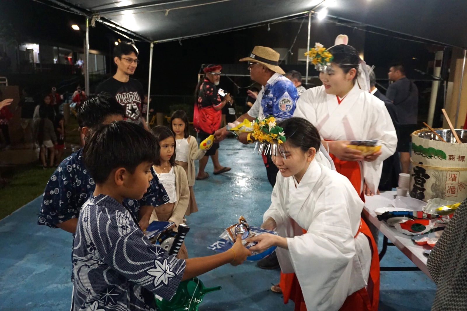 Visitors from Japan’s Katori Shrine give toys to the children during the Autumn Festival at Sugar King Park on Saturday.