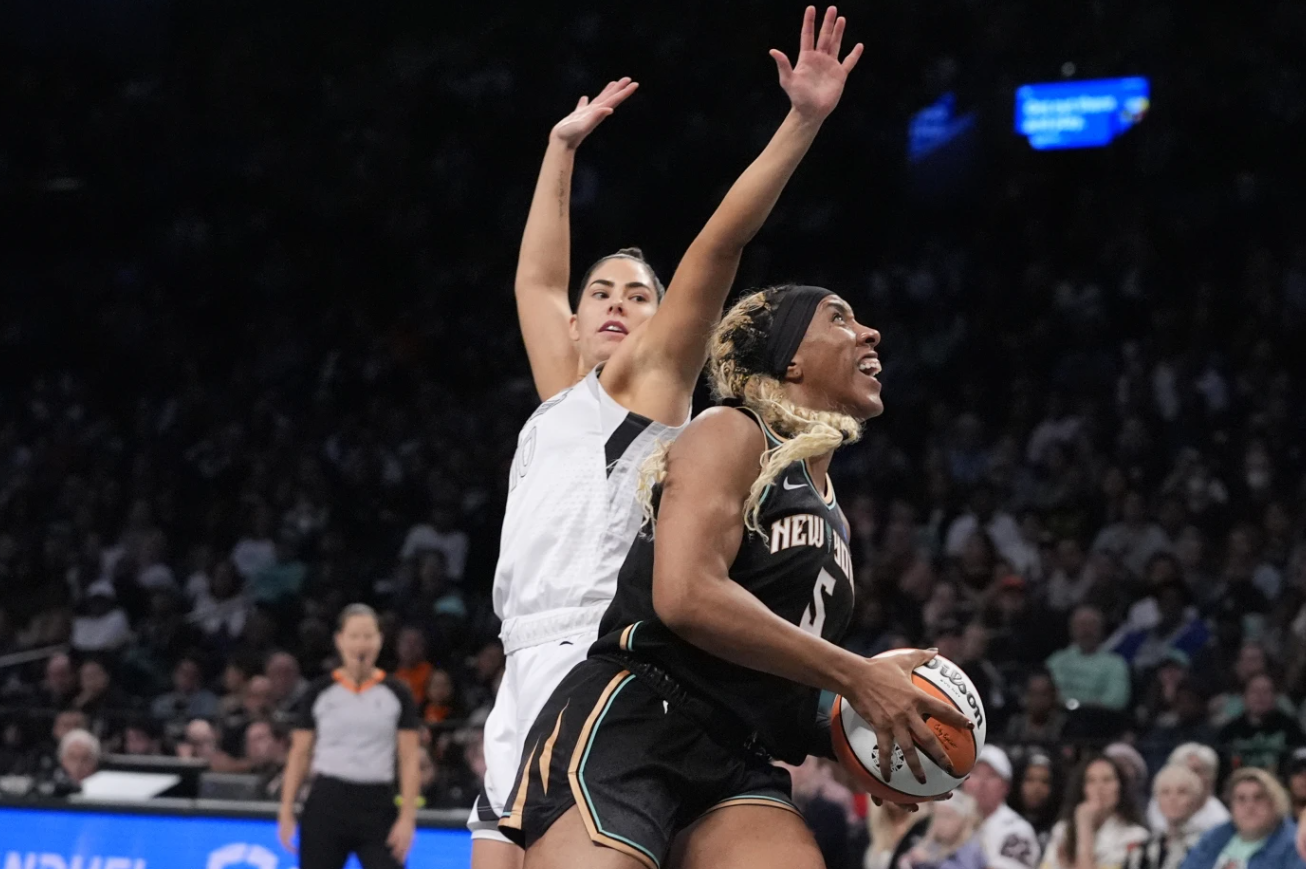 New York Liberty’s Kayla Thornton (5) drives past Las Vegas Aces’ Kelsey Plum (10) during the first half of a WNBA semifinal game, Tuesday, Oct. 1, 2024 in New York.