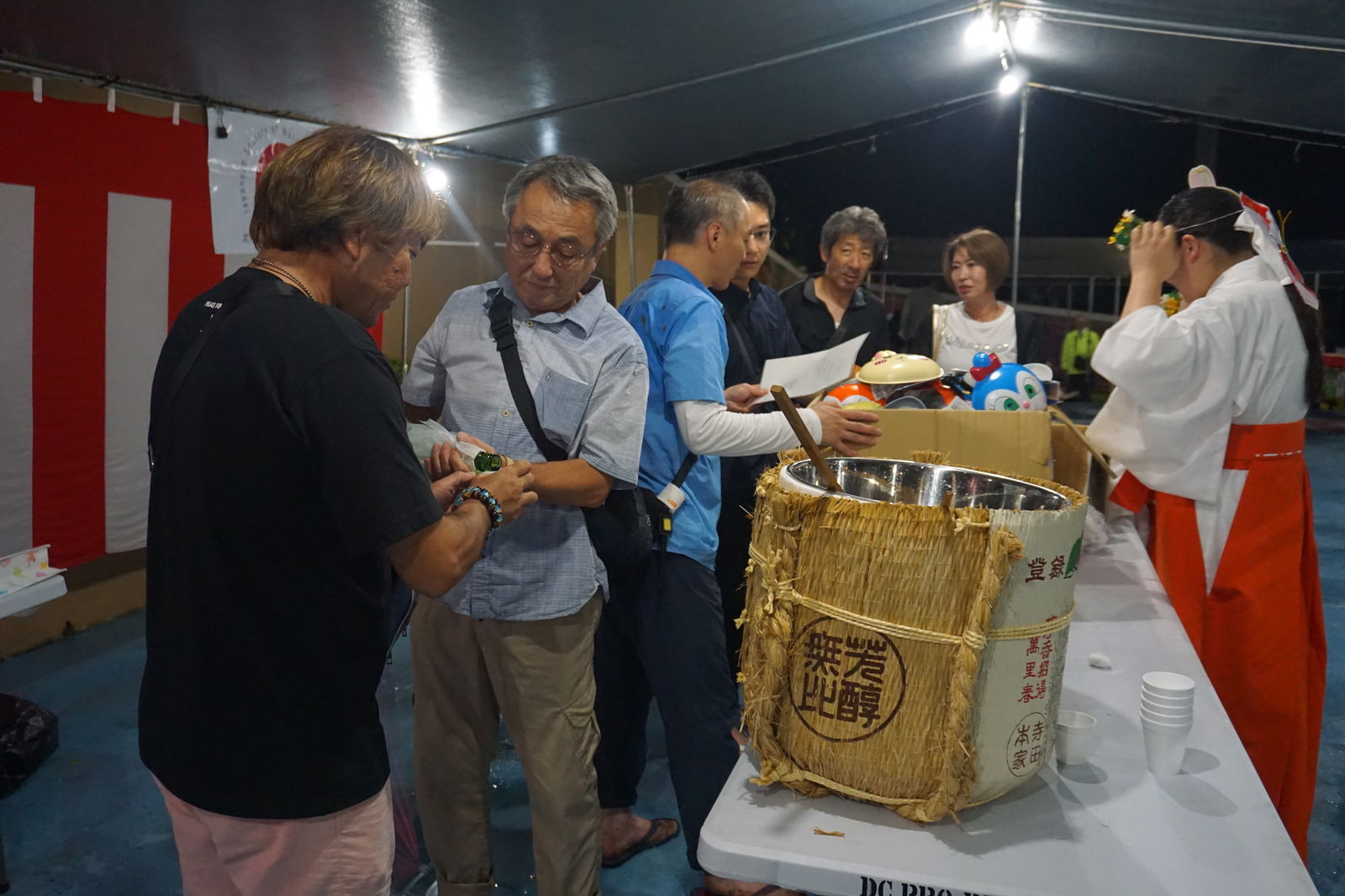 A visiting member of the Katori Shrine delegation serves sake.