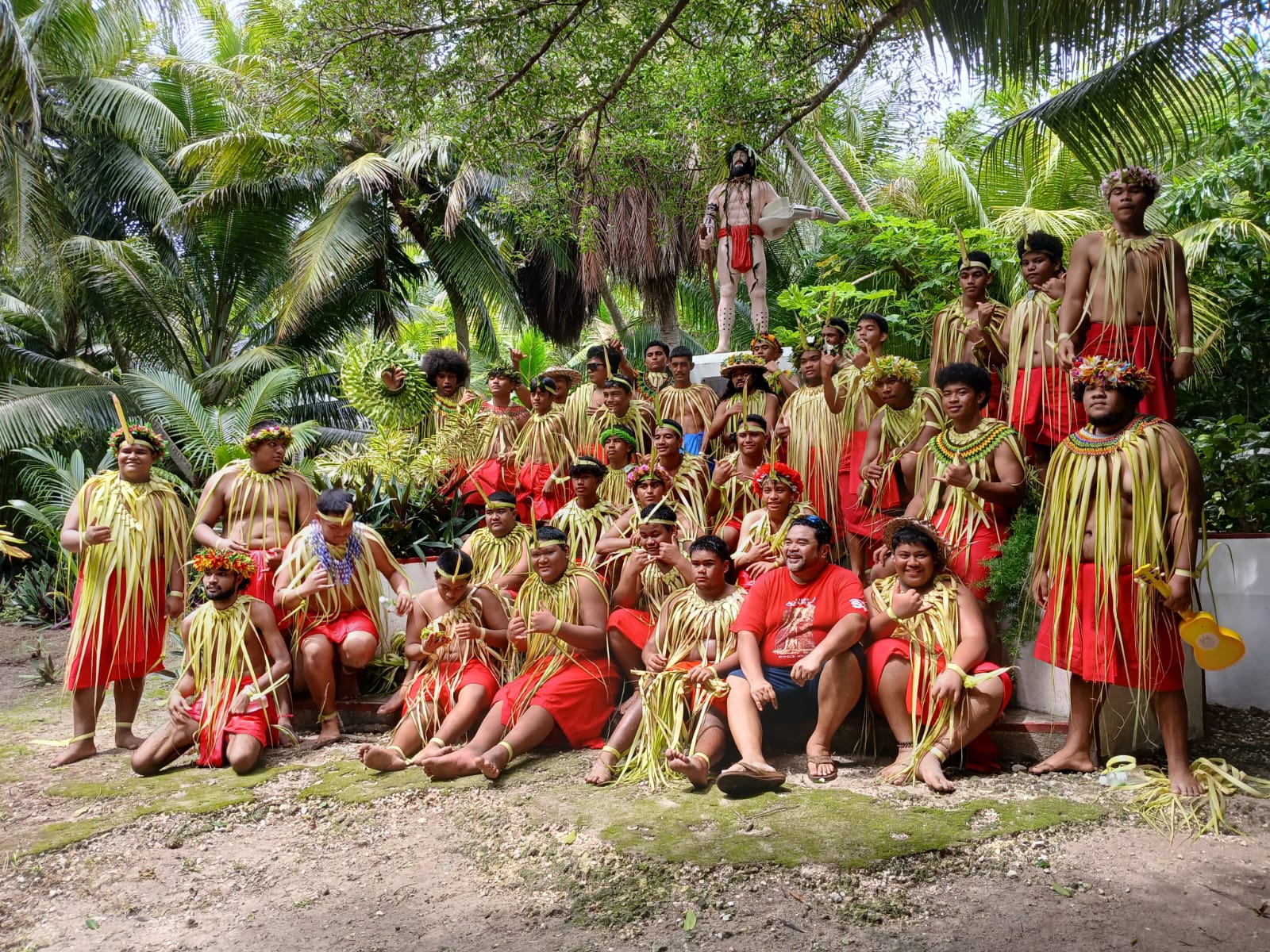 Members of a cultural dance group pose for photo with Chief Aghurubw Foundation President Kodep Ogumoro-Uludong near  the statue of Chief Aghurubw on Managaha.
