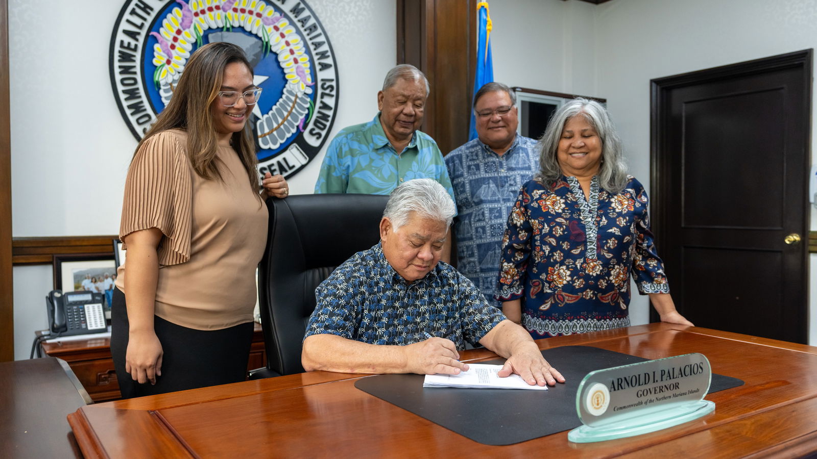Gov. Arnold I. Palacios signs the government’s fiscal year 2025 budget measure as Lt. Gov. David M. Apatang, Finance Secretary Tracy B. Norita, Special Assistant for Management and Budget Vicky Villagomez and OMB Budget Officer Edward Tenorio look on in the governor's conference room on Capital Hill, Monday.