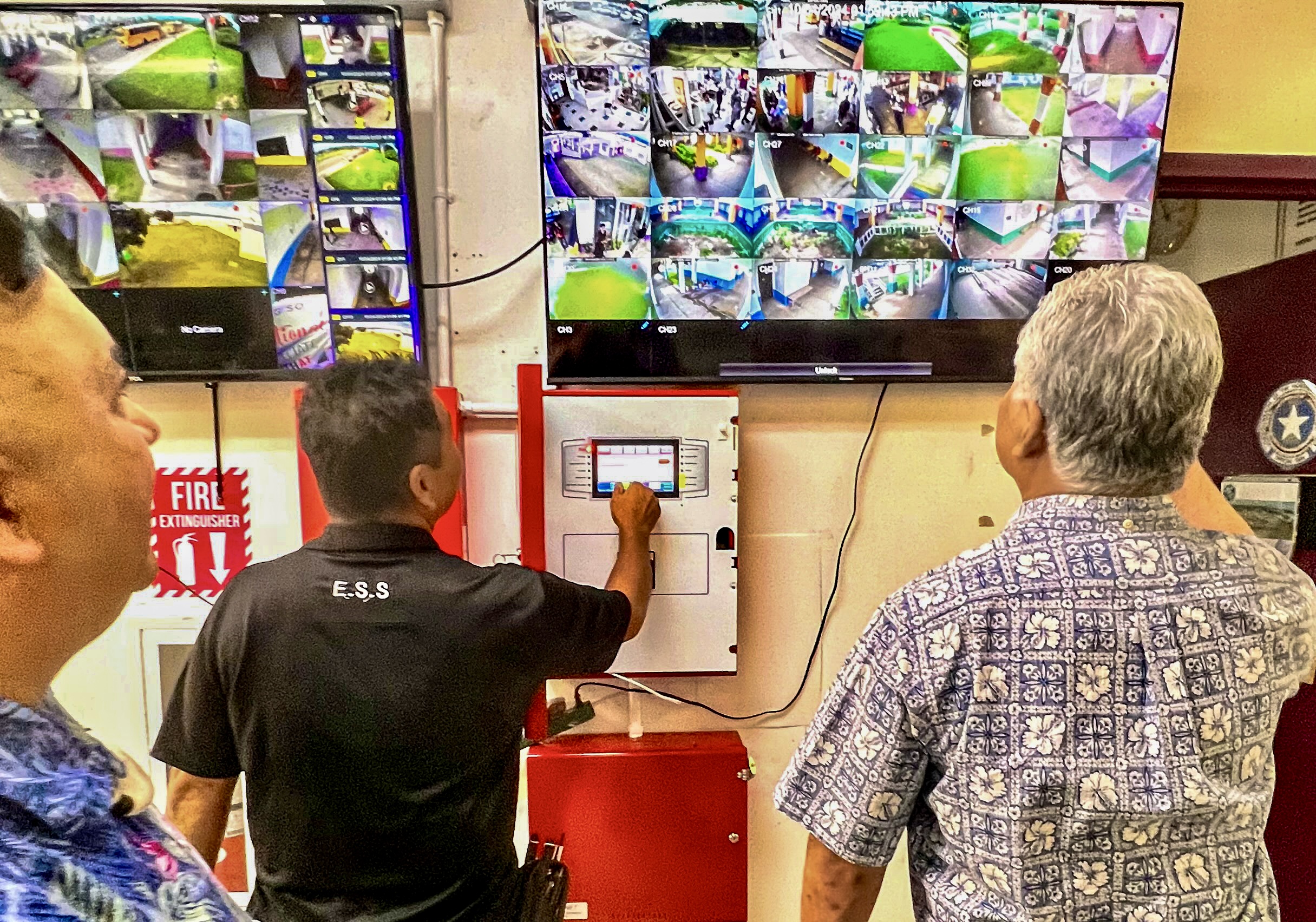 At Kagman Elementary School on Friday, Commissioner of Education Dr. Lawrence F. Camacho and Gov. Arnold I. Palacios are briefed about the new computerized alarm, bell and security system implemented in all public schools.