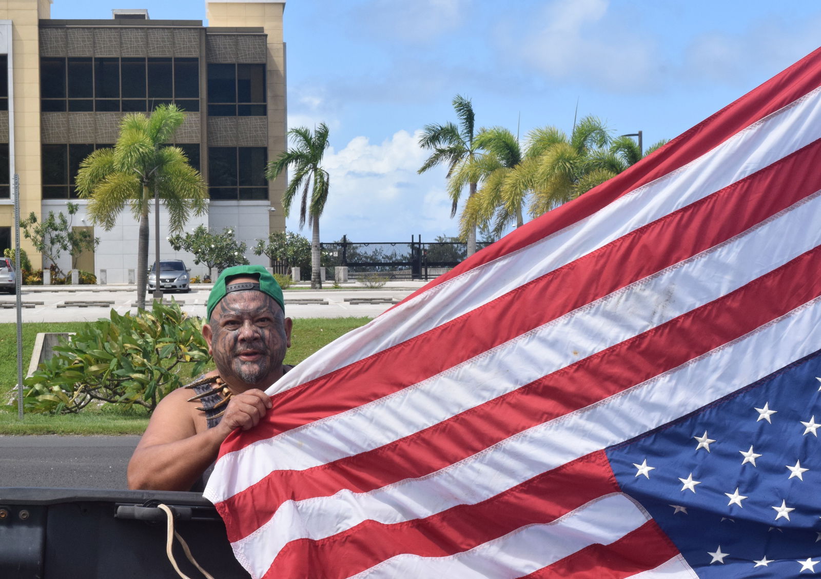 Local activist Raymond Quitugua displays an inverted U.S. flag outside the United States Courthouse in Gualo Rai on Thursday.