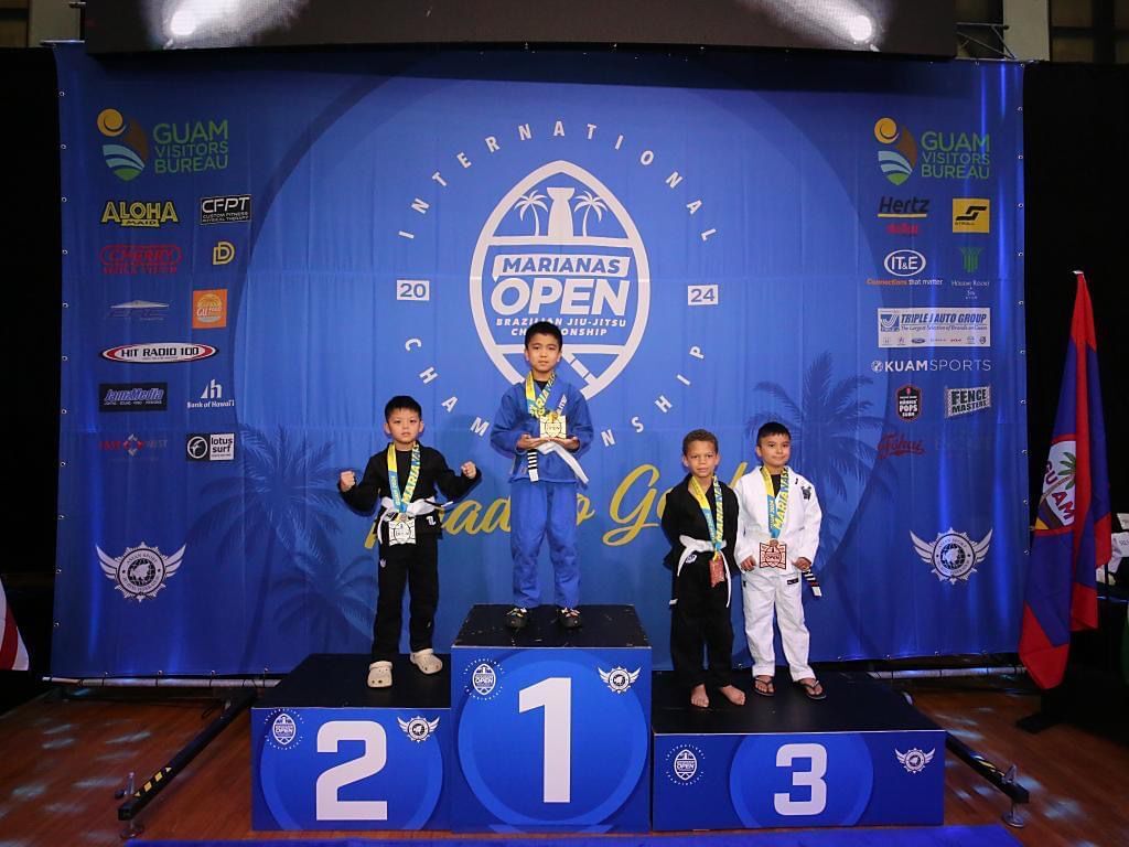 Chance Attao, left, is the silver medalist in the White Belt Kindergarten Lightweight Division of the 2024 Marianas Open International Championship Jiu-Jitsu Tournament at the University of Guam Calvo Field House on last Saturday. 