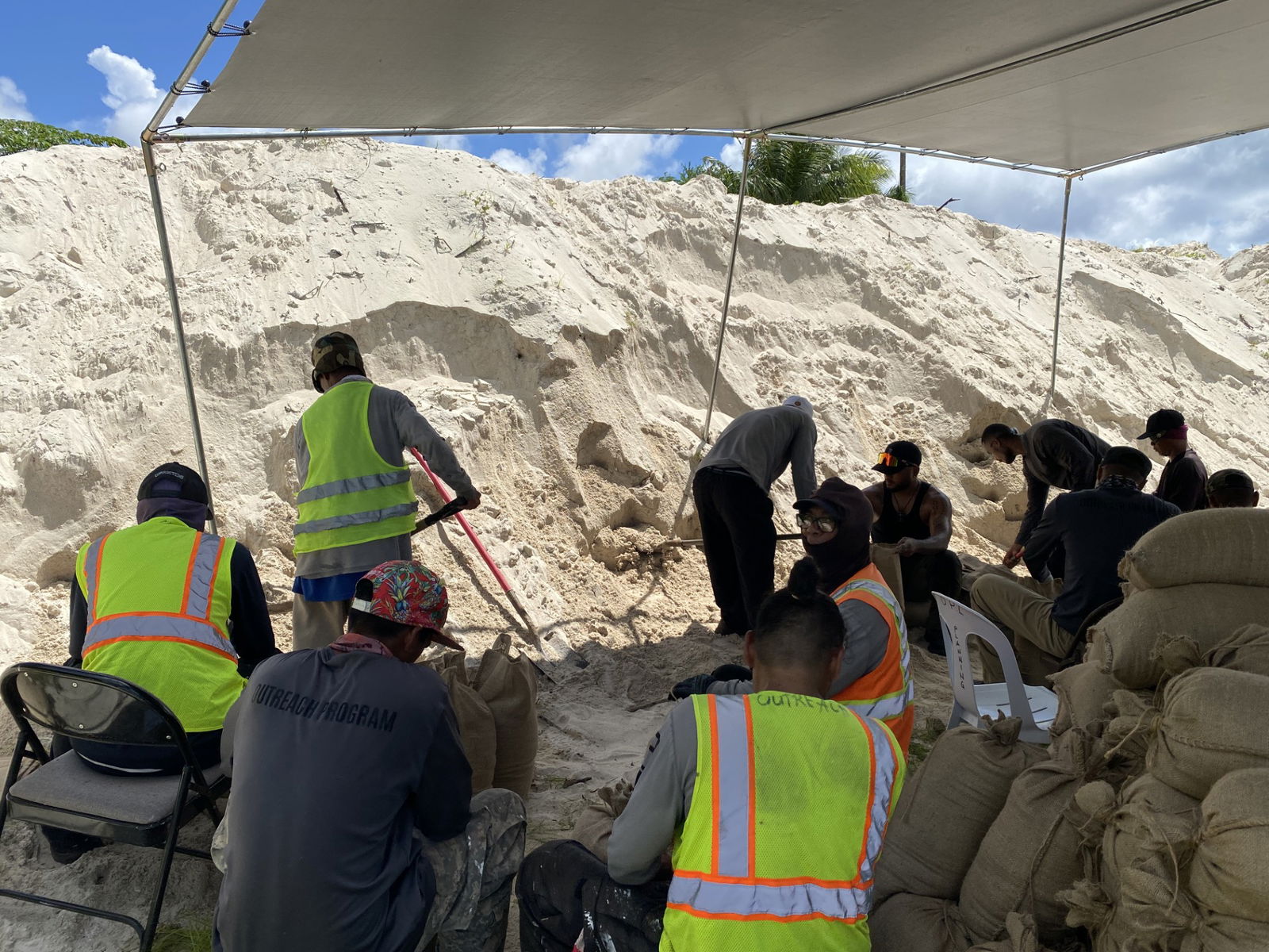 Department of Corrections Outreach Program members fill burlap bags with sand piled at the Ada gym on Wednesday, Oct. 2.