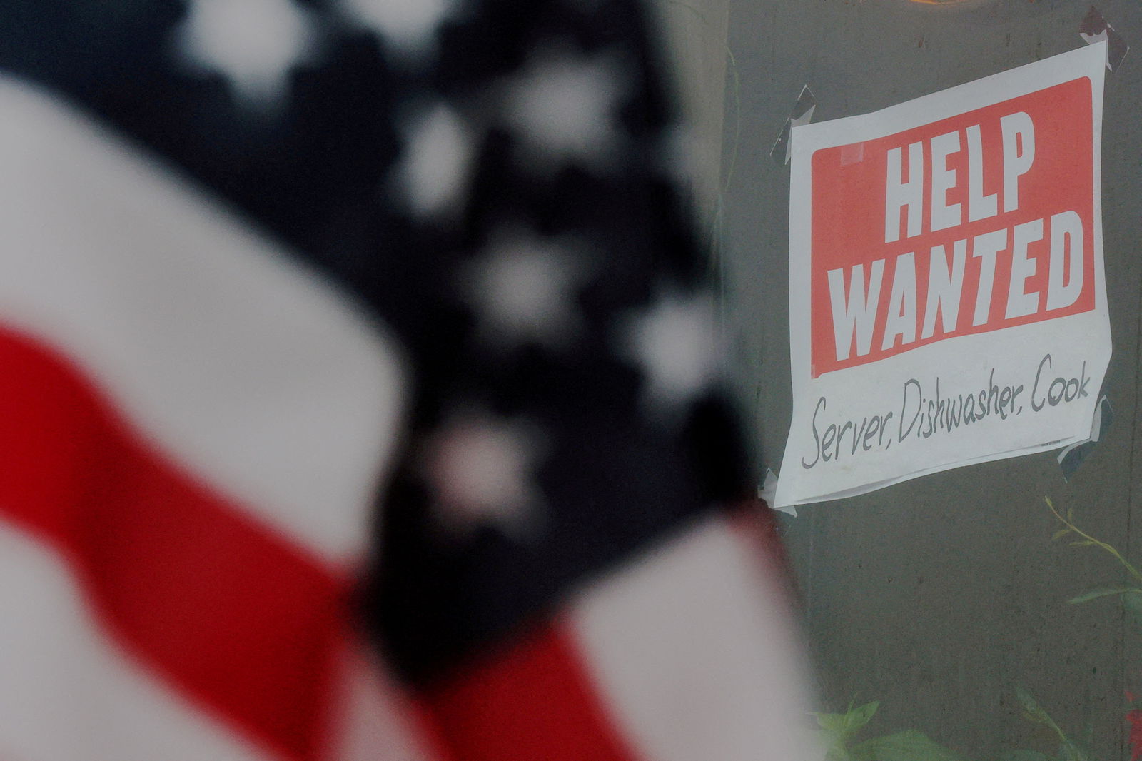 A “Help Wanted” sign hangs in restaurant window in Medford, Massachusetts, Jan. 25, 2023.