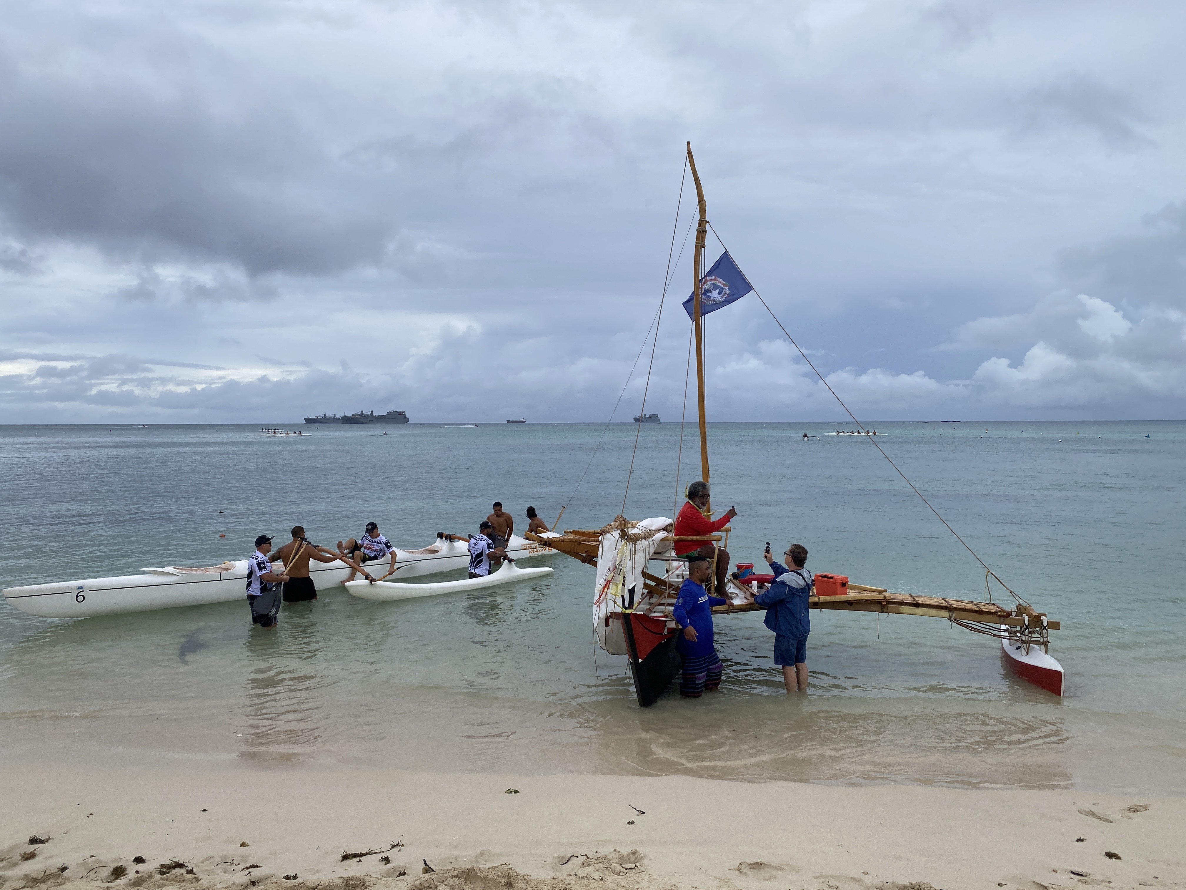 Master Navigator Mario Benito sits on Mikaela while a racing crew prepare their va'a in the Saipan Lagoon.