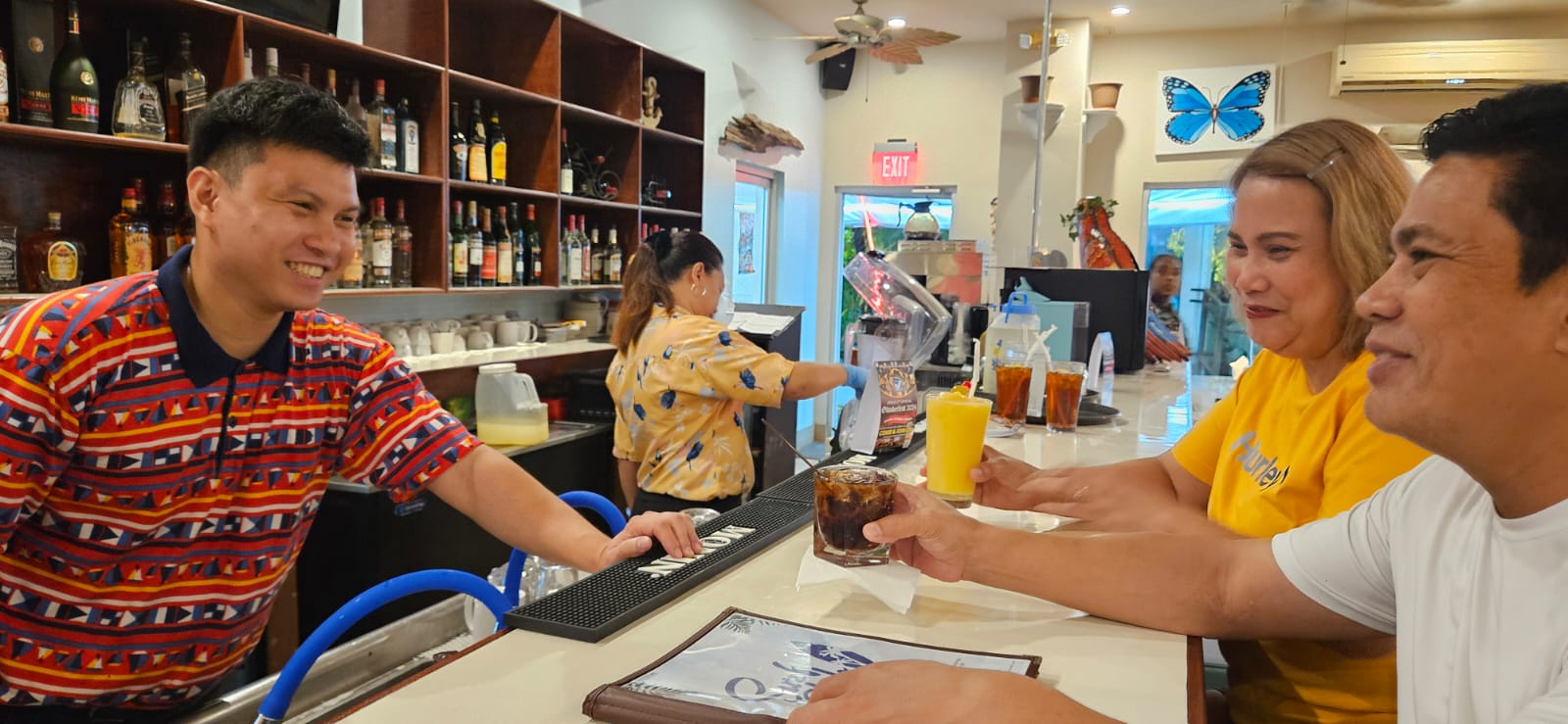 General Manager Paul Manicad, left, attends to two Surf Club Restaurant patrons.