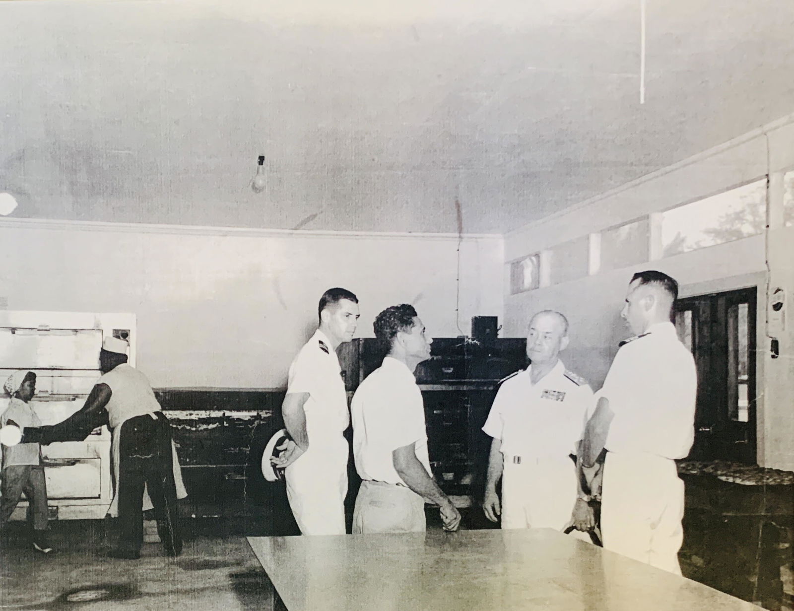 Herman Jose R. Guerrero is visited by US Navy officials at his bakery. The US Navy has tasked Tun Herman Pan to help feed the people of Saipan during the post-War reconstruction phase of the island. Tun Herman Pan and his wife, Maria Juliana or Tan Marikita Pan, played very critical role in the recovery of the island following the Battle of Saipan that ended the 30 years Japanese administration.