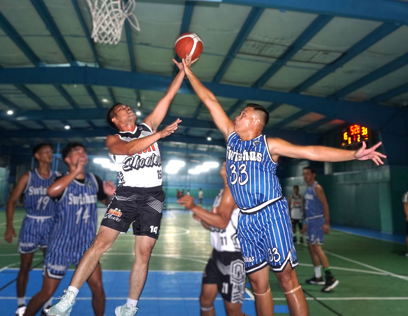 Swishas' Arfin Chua extends to deny the shot of UMI Shooters' Alvin Pantola during a semi-open division game of the Win Pacific Corporation Invitational Basketball League 2024 at the TSL Sports Complex.