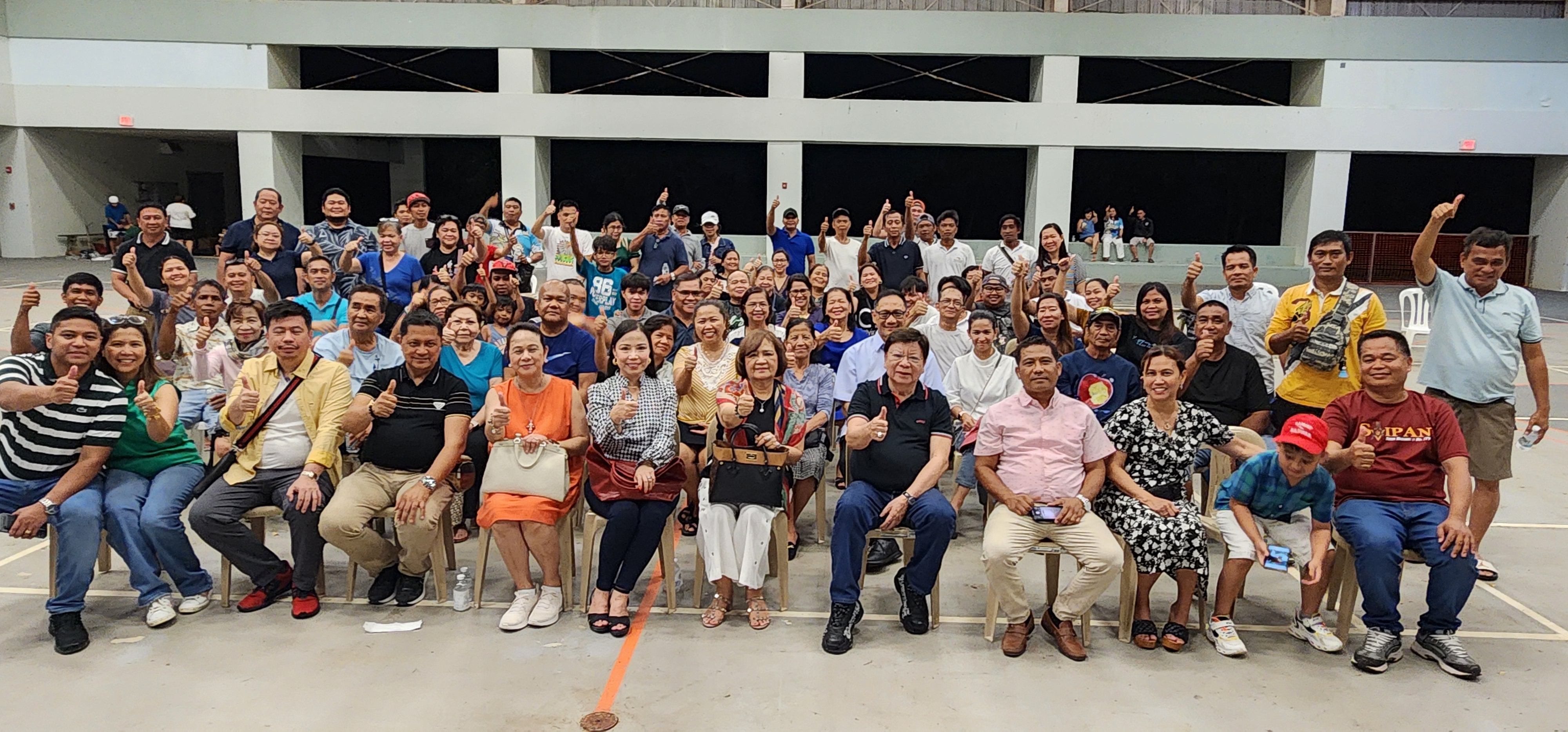 Philippine Congressman Rodante Marcoleta, fifth right seated, and wife, Edna, center, join members of the Filipino community in the CNMI during a “meet-and-greet” event at the Koblerville basketball court on Friday.