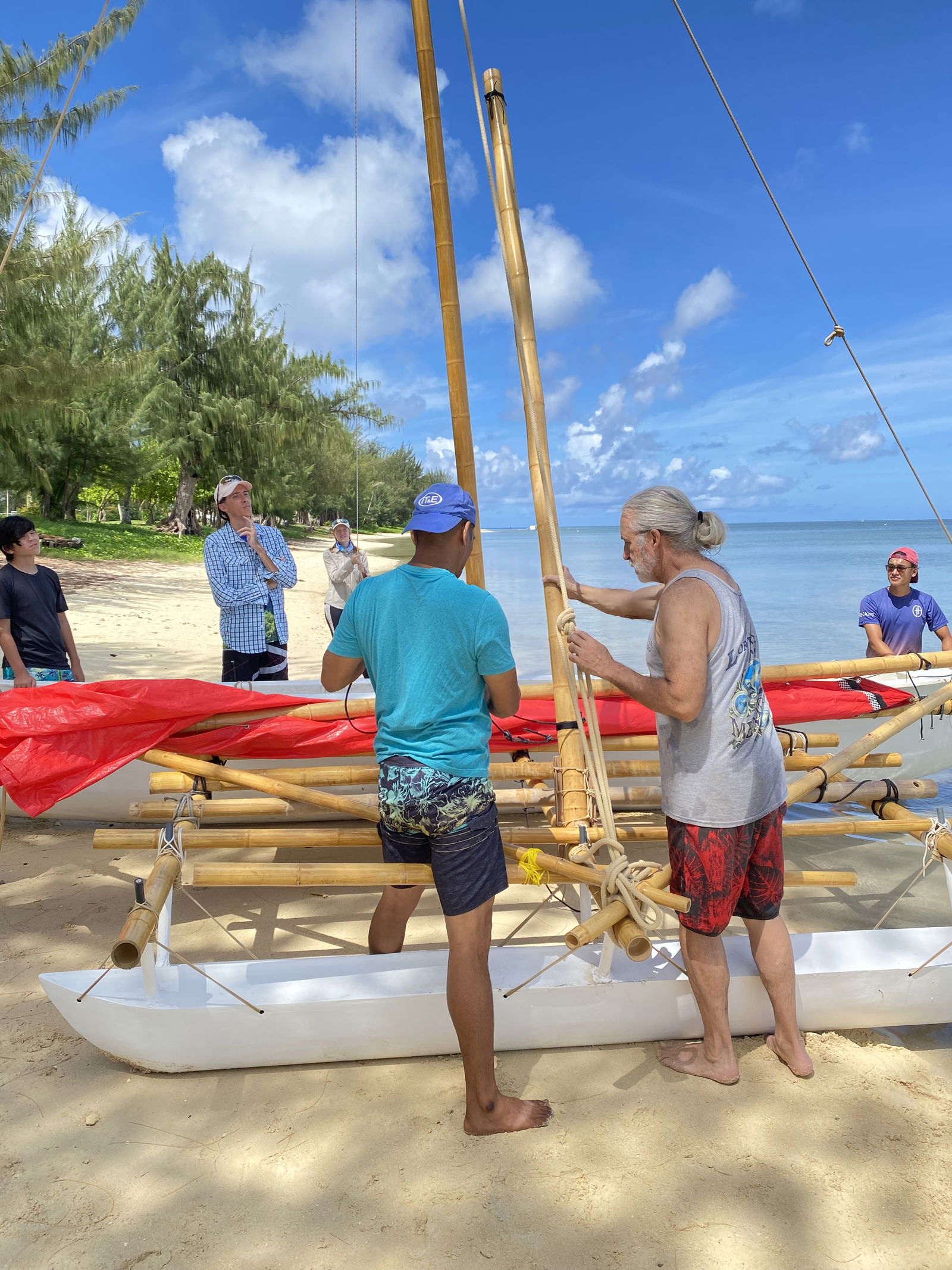 Peter Perez, 500 Sails cofounder, right, teaches how to lash a leklek, or 26-foot-long canoe, during Lalayak, 500 Sails sailing course. 