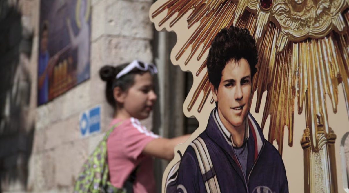 A girl visits the tomb of Carlo Acutis, who died of leukemia in 2006 aged 15, in the Church of Santa Maria Maggiore in Assisi, Italy, May 26, 2024.