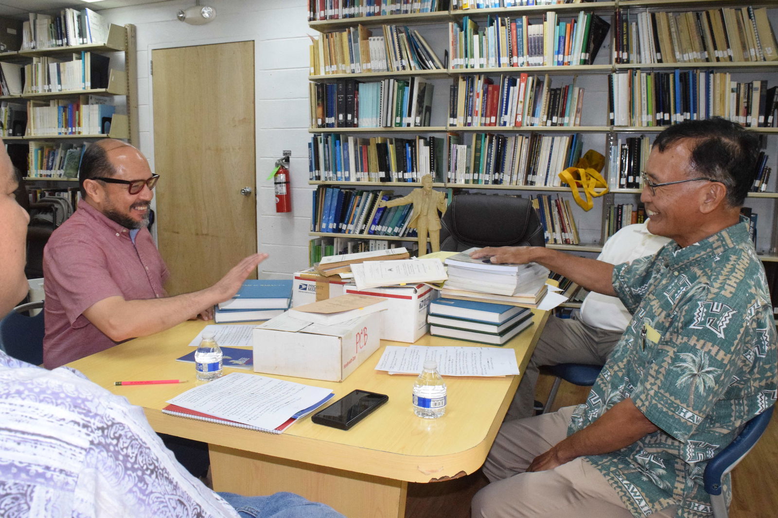 On behalf of Northern Marianas College, its President Dr. Galvin S. Deleon Guerrero, left, receives the documents and books donated by former Gov. Juan Nekai Babauta.