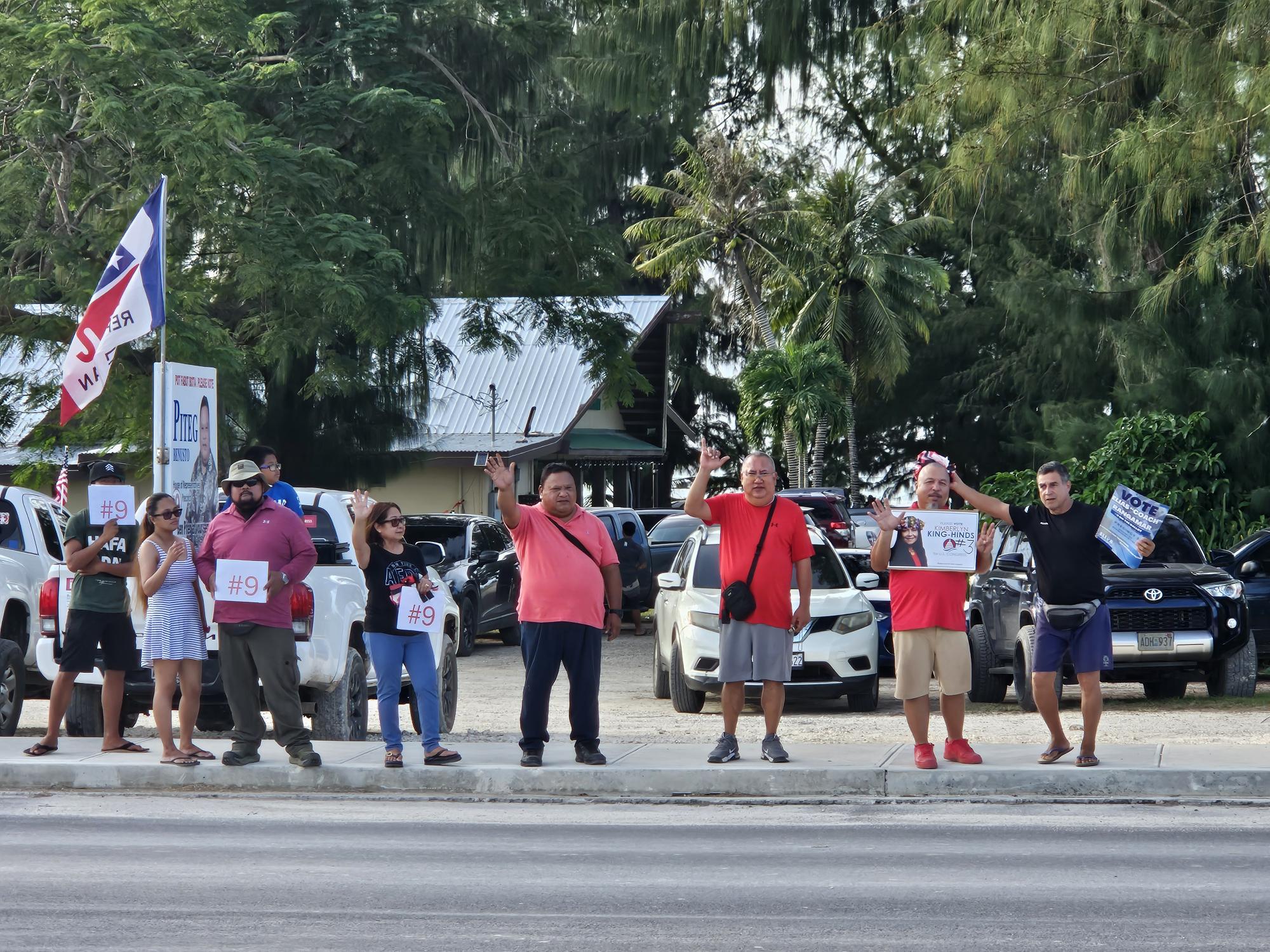 Precinct 1 candidate Benusto Piteg of the Republican Party, wife Evelyn and supporters wave at motorists on Sunday.