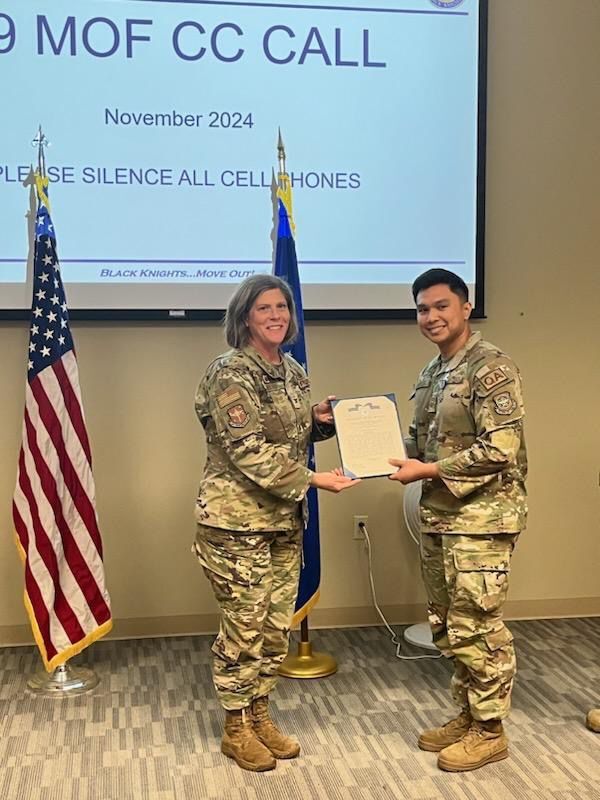 Air Force Technical Sgt. Adam J. Santos, right, with Col. Amanda Sheets of the 19th Airlift Wing at Little Rock Air Force Base in Arkansas.