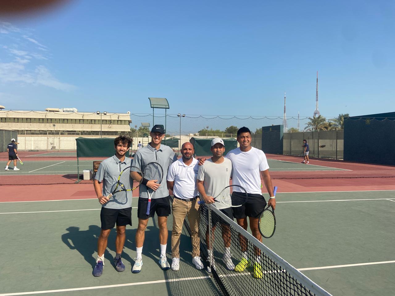 Team NMI's Robbie Schorr, left, and Colin Sinclair, 2nd left, pose with their opponents and a game official before a match in the 2024 Davis Cup at the Bahrain Tennis Federation tennis courts in Isa Town, Bahrain. 