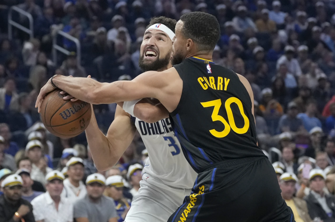 Dallas Maverick guard Klay Thompson, left, loses the ball while driving to the basket against Golden State Warriors guard Stephen Curry during the first half of an Emirates NBA Cup game in San Francisco, Tuesday, Nov. 12, 2024