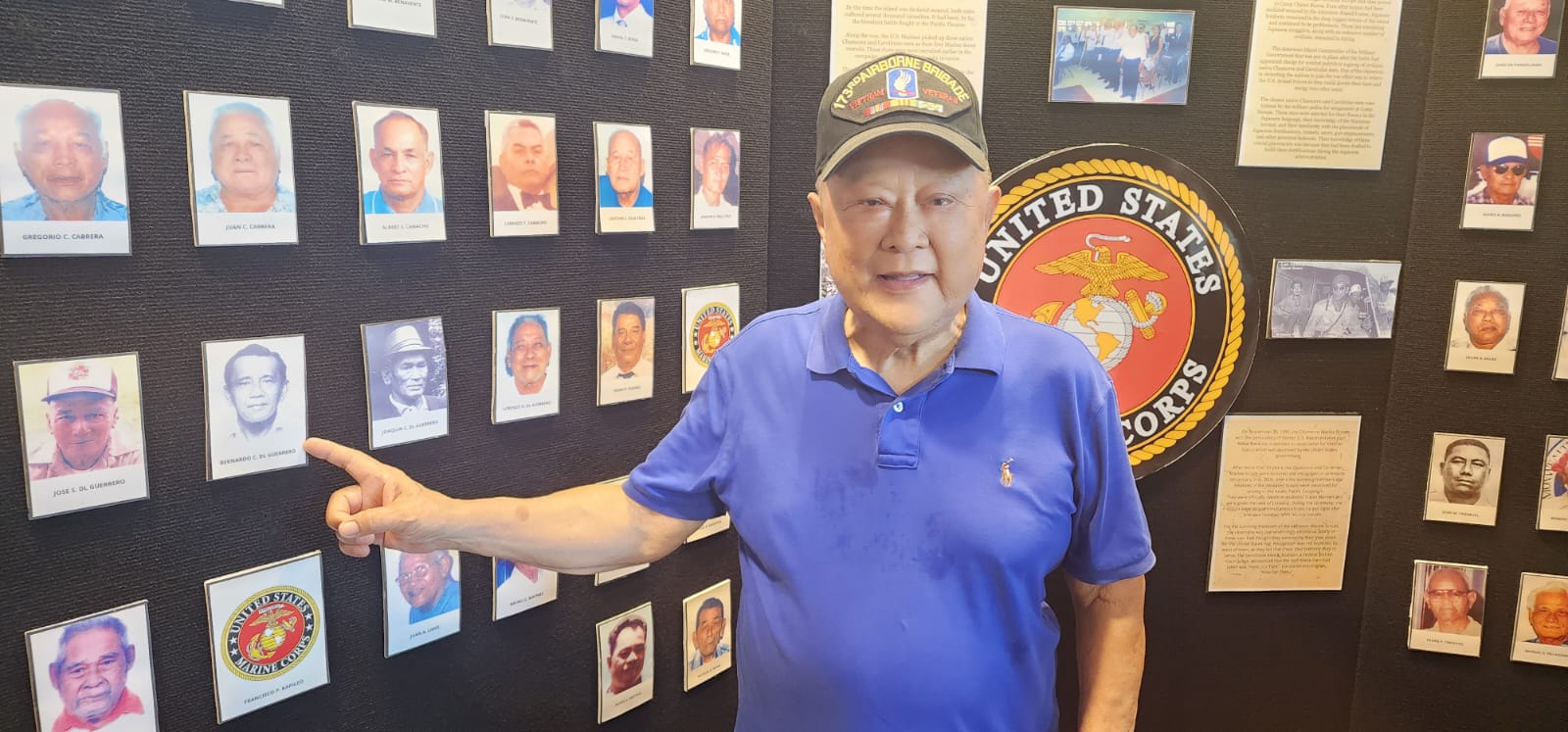 Antonio Guerrero, who was U.S. Army paratrooper, points to the picture of his father Bernardo Guerrero, a member of the U.S. Marine scouts during World War II.