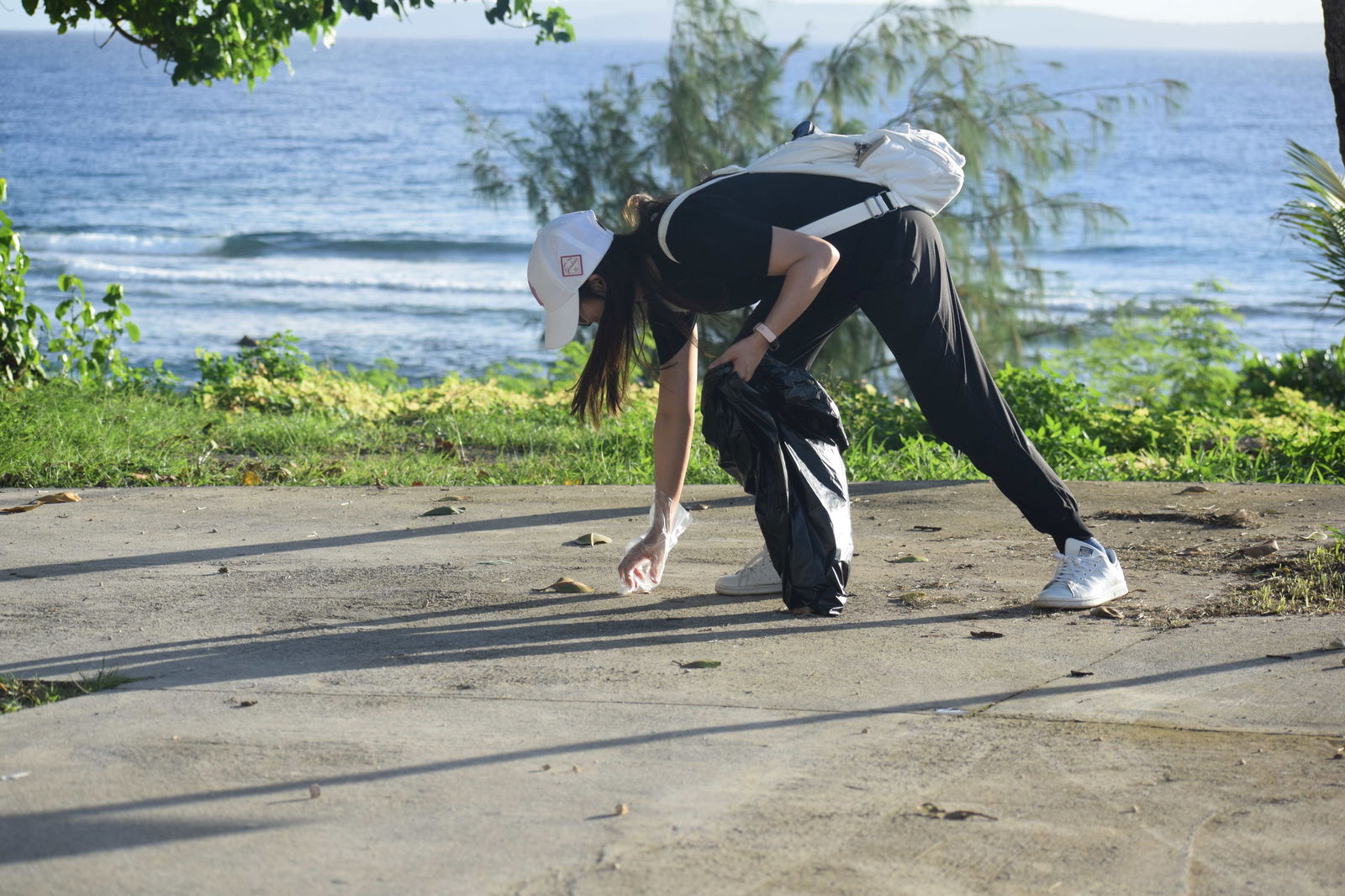 P&A Corporation President Doyi Kim picks up trash near the pavilion at the Coral Ocean Resort beach.