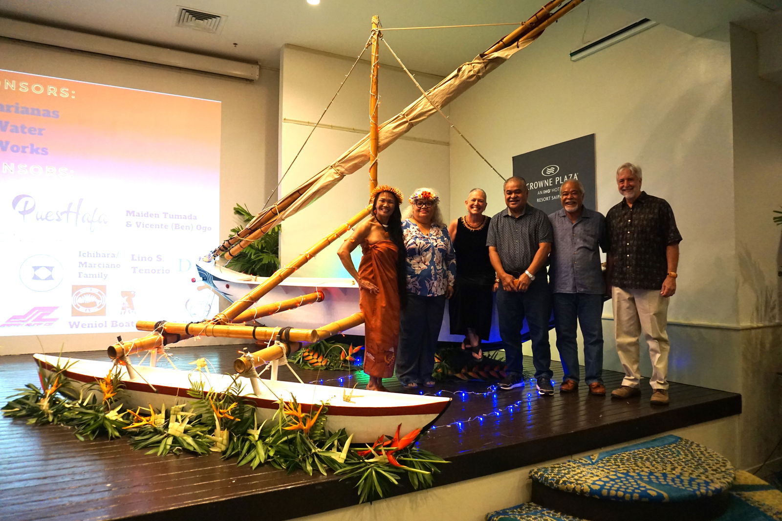 From left, Frances Sablan, Marianas Alliance of Non-Governmental Organizations executive director; Louella Marciano, Indigenous Affairs Office resident executive; Emma Perez, 500 Sails cofounder; Frank Rabauliman, Commonwealth Economic Development Authority chair; Felix Nogis, Carolinian Affairs Office executive assistant; and Peter Perez, 500 Sails cofounder pose for a picture in front of Animuyi, who made an appearance at the 500 Sails fundraiser gala as a decorative stage piece.