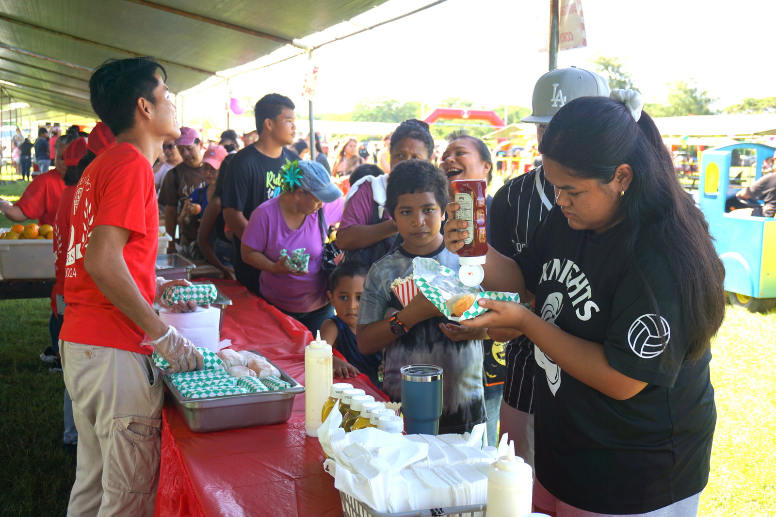 Community members receive free hot dogs during Herman’s Modern Bakery Family Fun Day event on Saturday, Nov. 9.