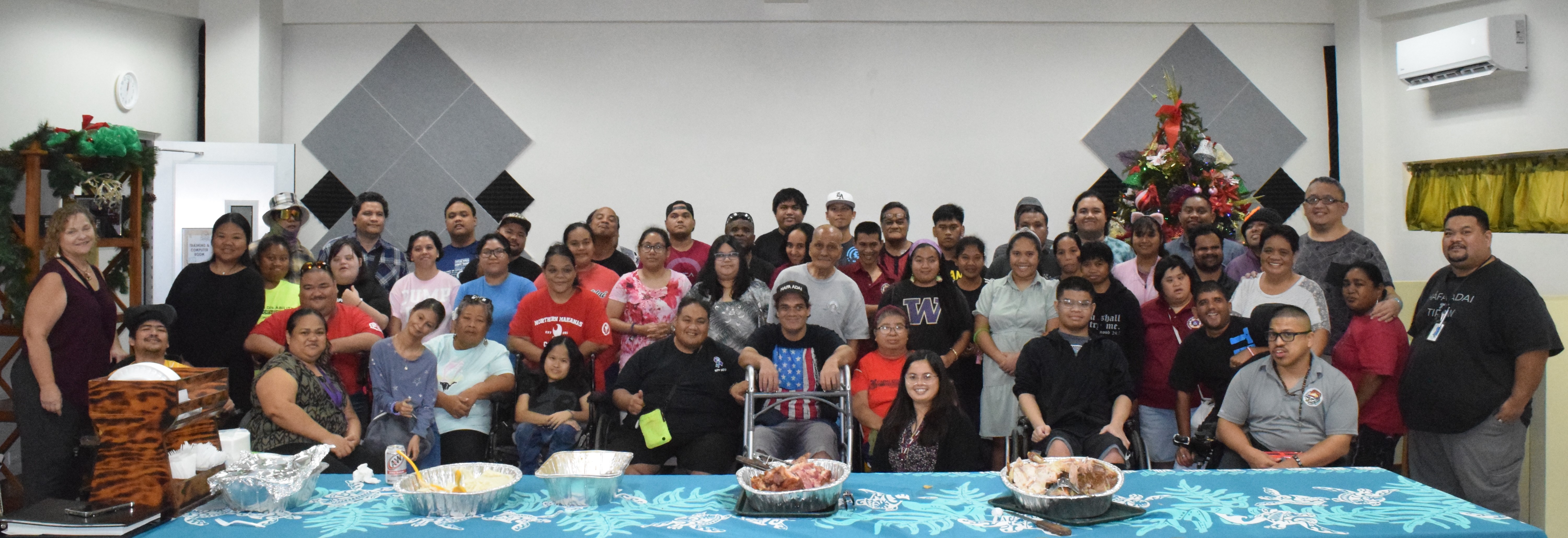 Center for Living Independently Director Susan Satur, left, and CLI consumers pose for a photo during the Thanksgiving luncheon hosted by the First Lady Wella Palacios Foundation at CLI on Capital Hill Wednesday.