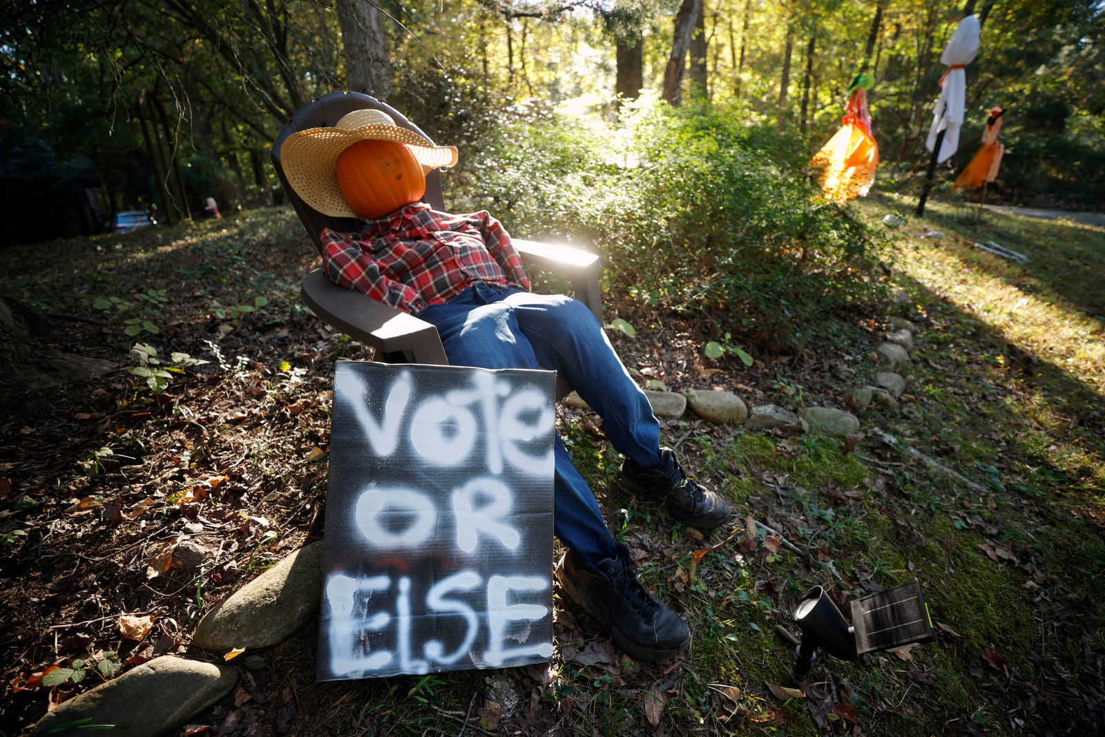 A hand-painted sign encouraging citizens to vote, sits with Halloween decorations in the front yard of a home in Chapel Hill, North Carolina, Oct. 20, 2024. 