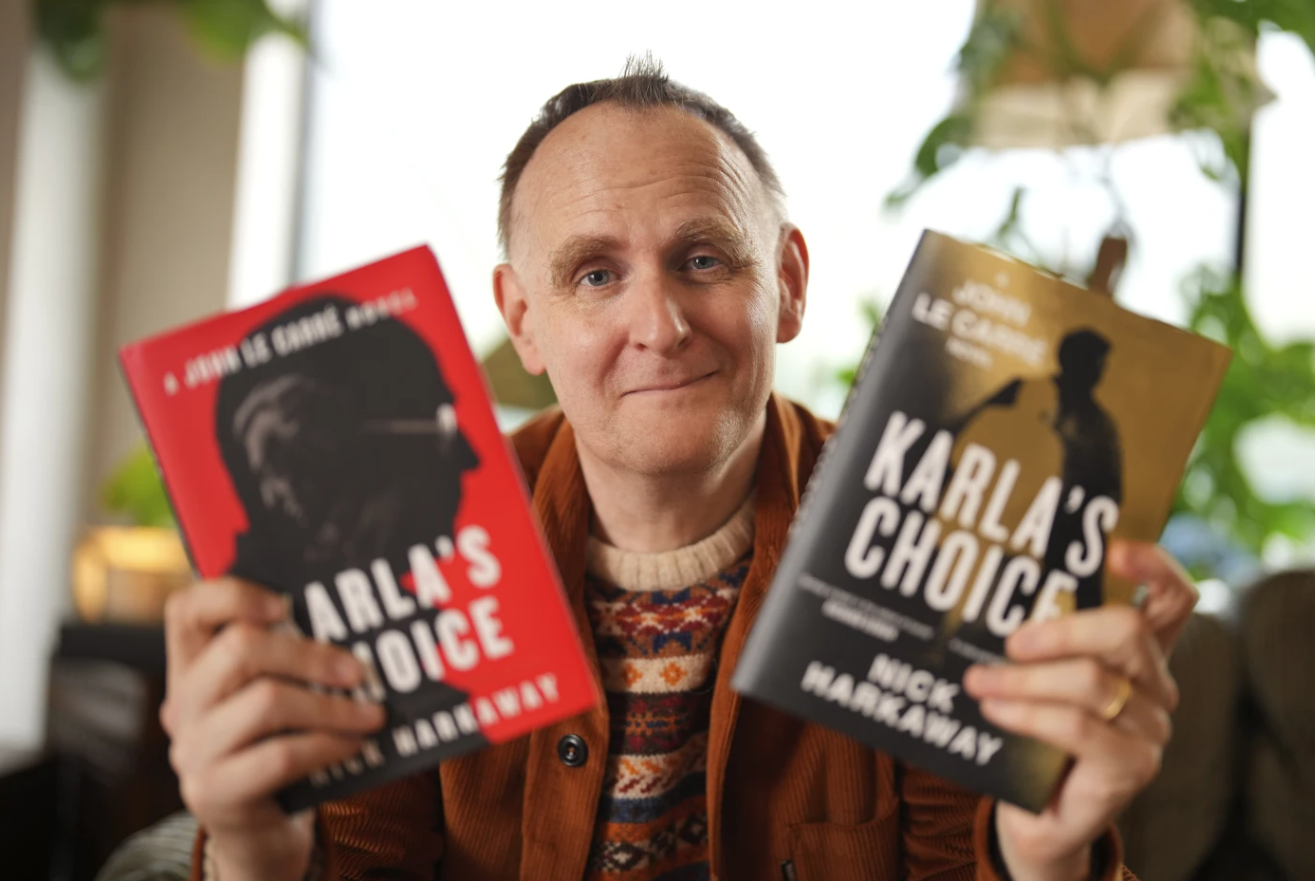 British author Nick Harkaway, son of John le Carré, poses for a photograph with copies of his book during an interview with The Associated Press at his home in London, Oct. 24, 2024.