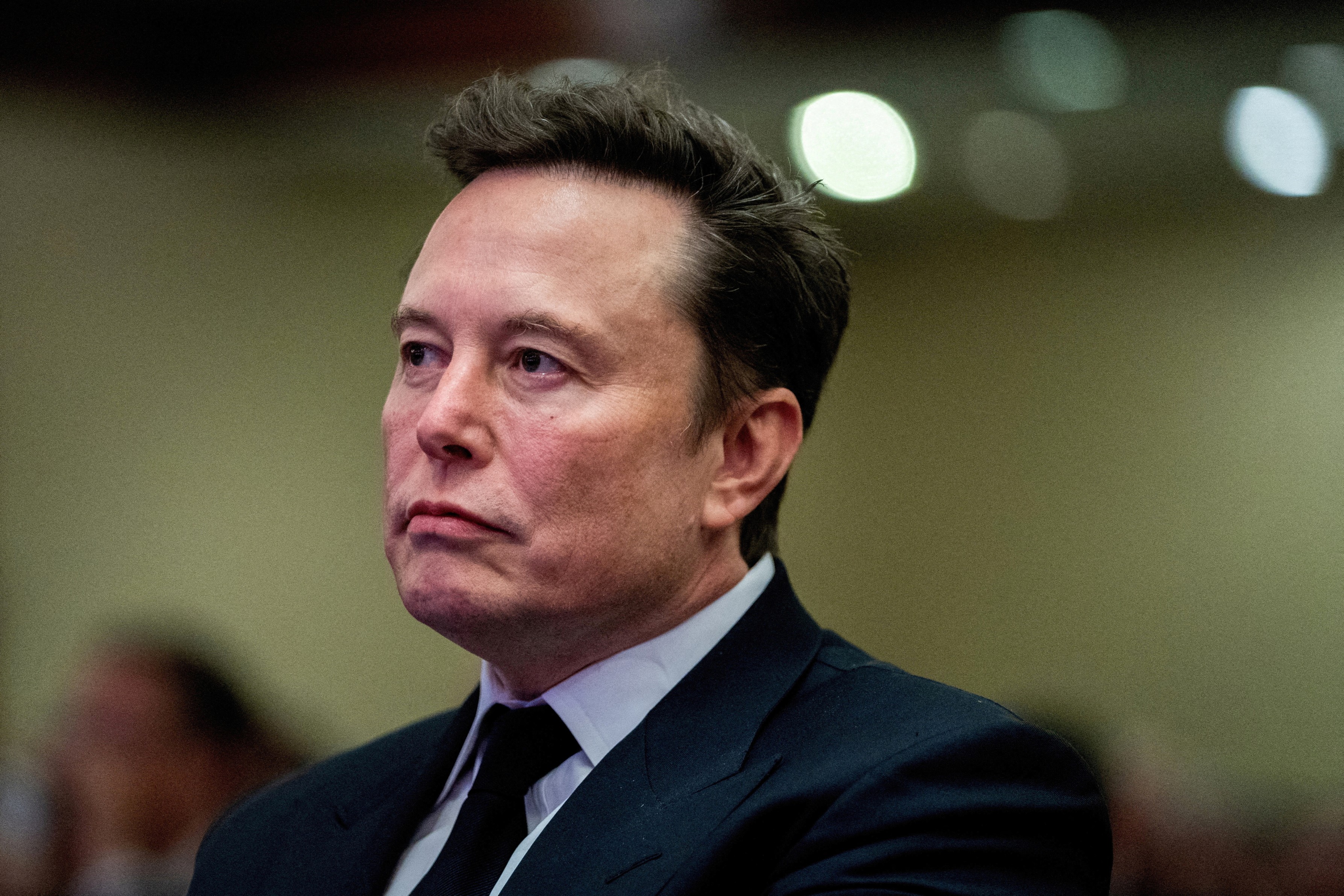 Tesla CEO and X owner Elon Musk listens as President-elect Donald Trump speaks during a meeting with House Republicans at the Hyatt Regency hotel in Washington, D.C., on Nov. 13, 2024.