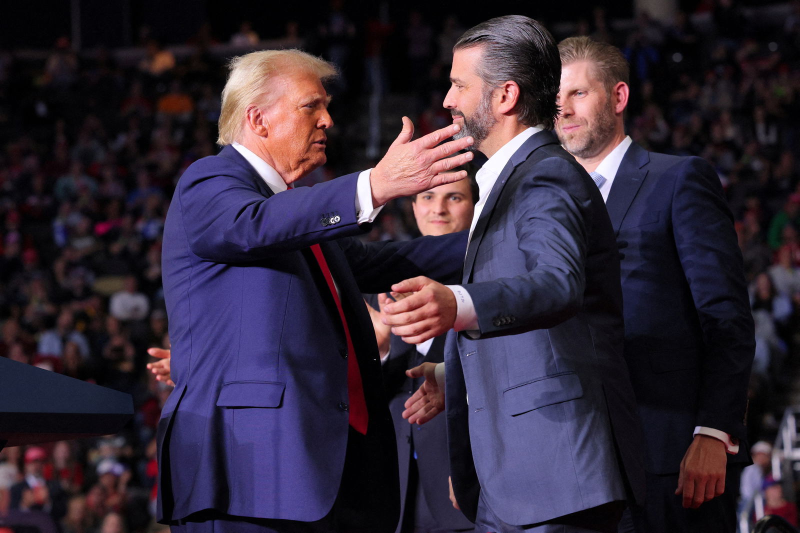 Republican presidential nominee Donald Trump approaches to embrace Donald Trump Jr. at a campaign rally in Pittsburgh, Pennsylvania, Nov. 4, 2024.