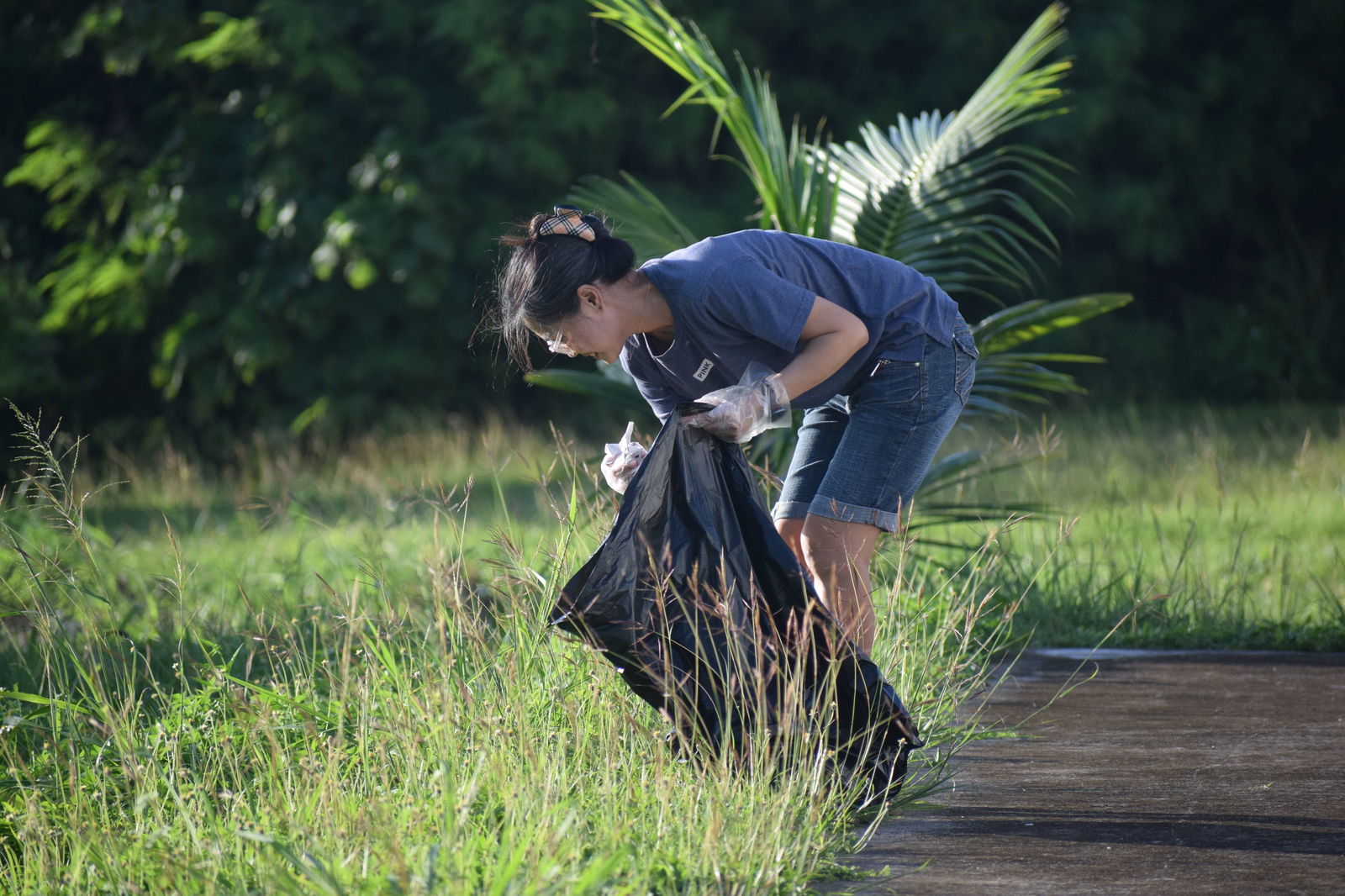 P&A Corporation Human Resource Manager Emer Banayos picks up trash in the Coral Ocean Resort beach area.
