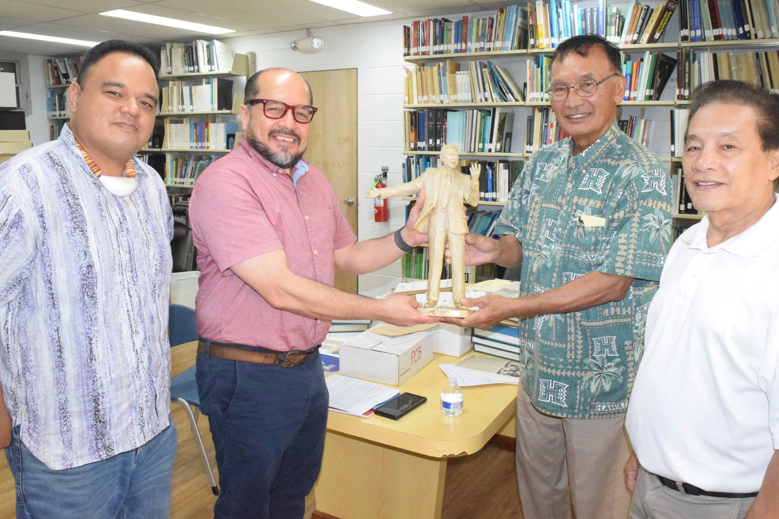 Former Gov. Juan Nekai Babauta, second right, hands the miniature statute of U.S. Congressman Phil Burton to Northern Marianas College President Dr. Galvin S. Deleon Guerrero, second left, while CNMI Archivist Ray Muna, left, and former Rep. Juan S. Reyes look on at the NMC Archives on Tuesday.