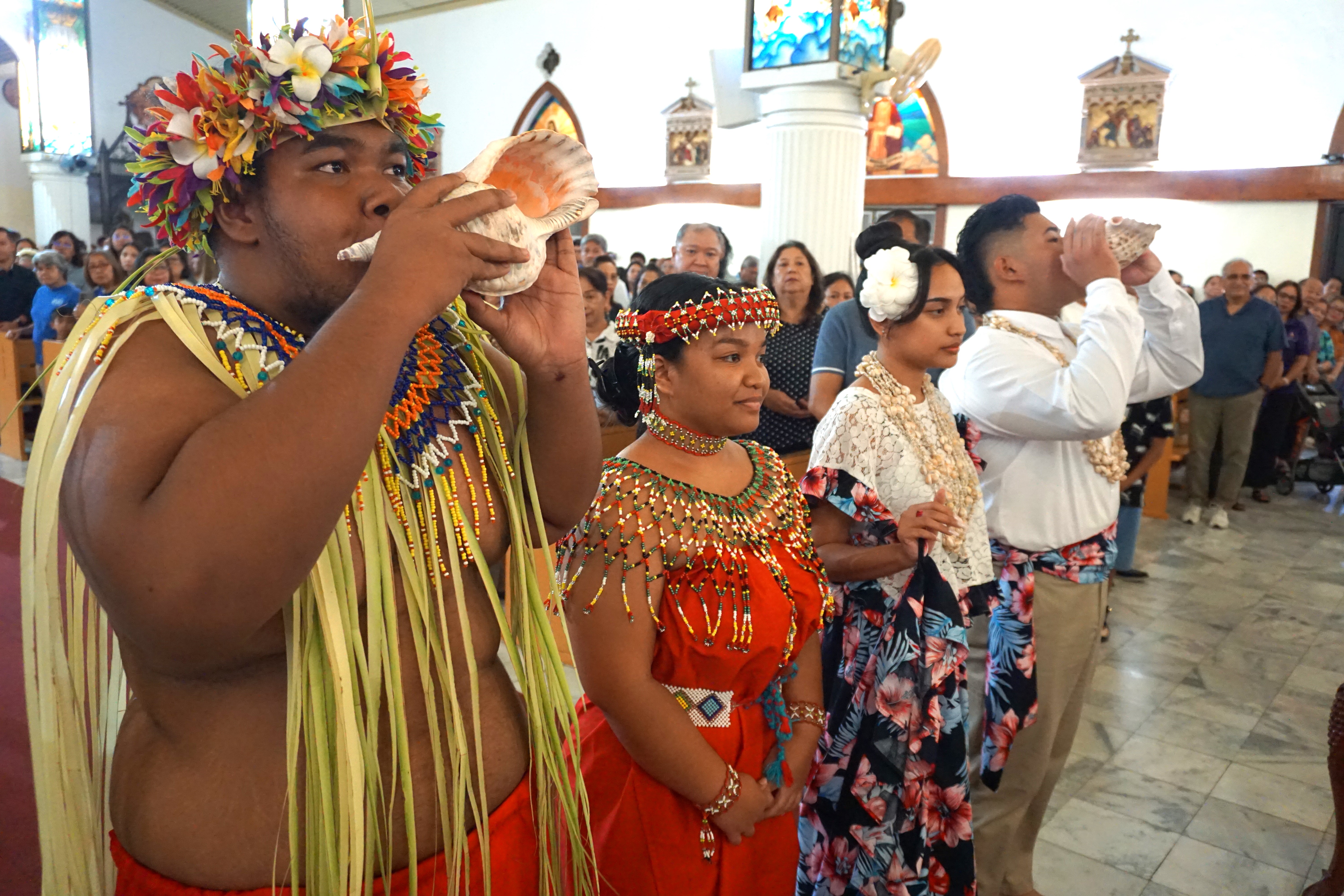 Island youths blow the kulu at the start of the Mass at the Mount Carmel Cathedral on Tuesday, Nov. 26, 2024.