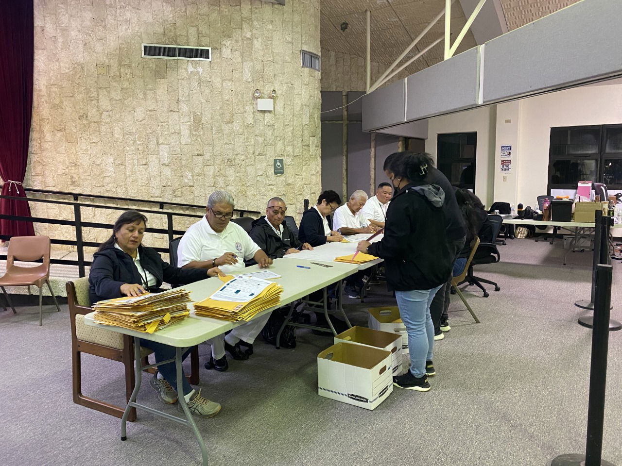 The Commonwealth Election Commission members examine some of the ballots at the multi-purpose center on Tuesday evening.