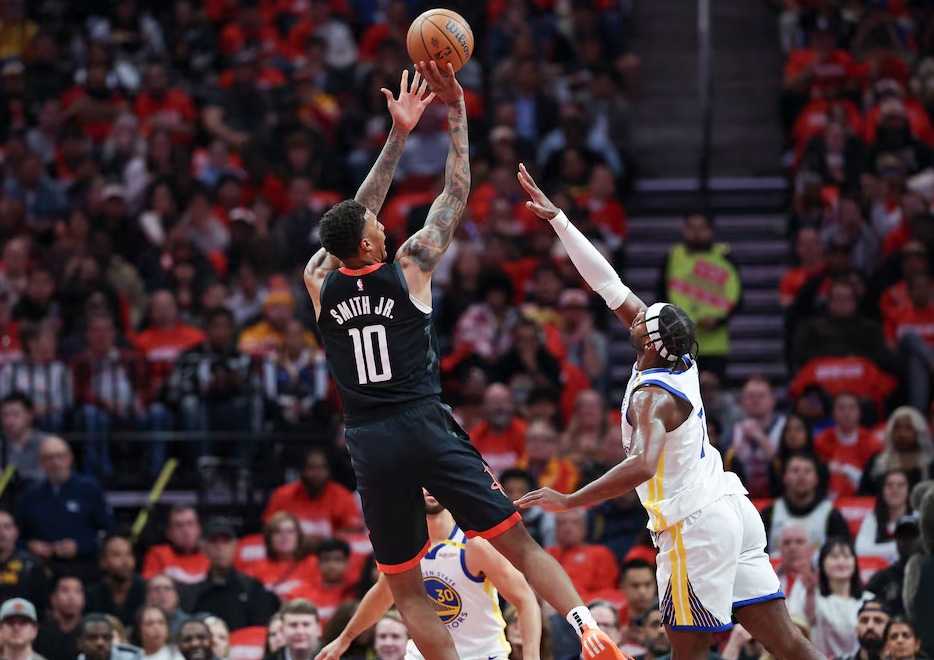 Houston Rockets forward Jabari Smith Jr. (10) shoots the ball as Golden State Warriors guard Buddy Hield (7) defends during the first quarter at Toyota Center in Houston, Texas, Dec. 11, 2024.